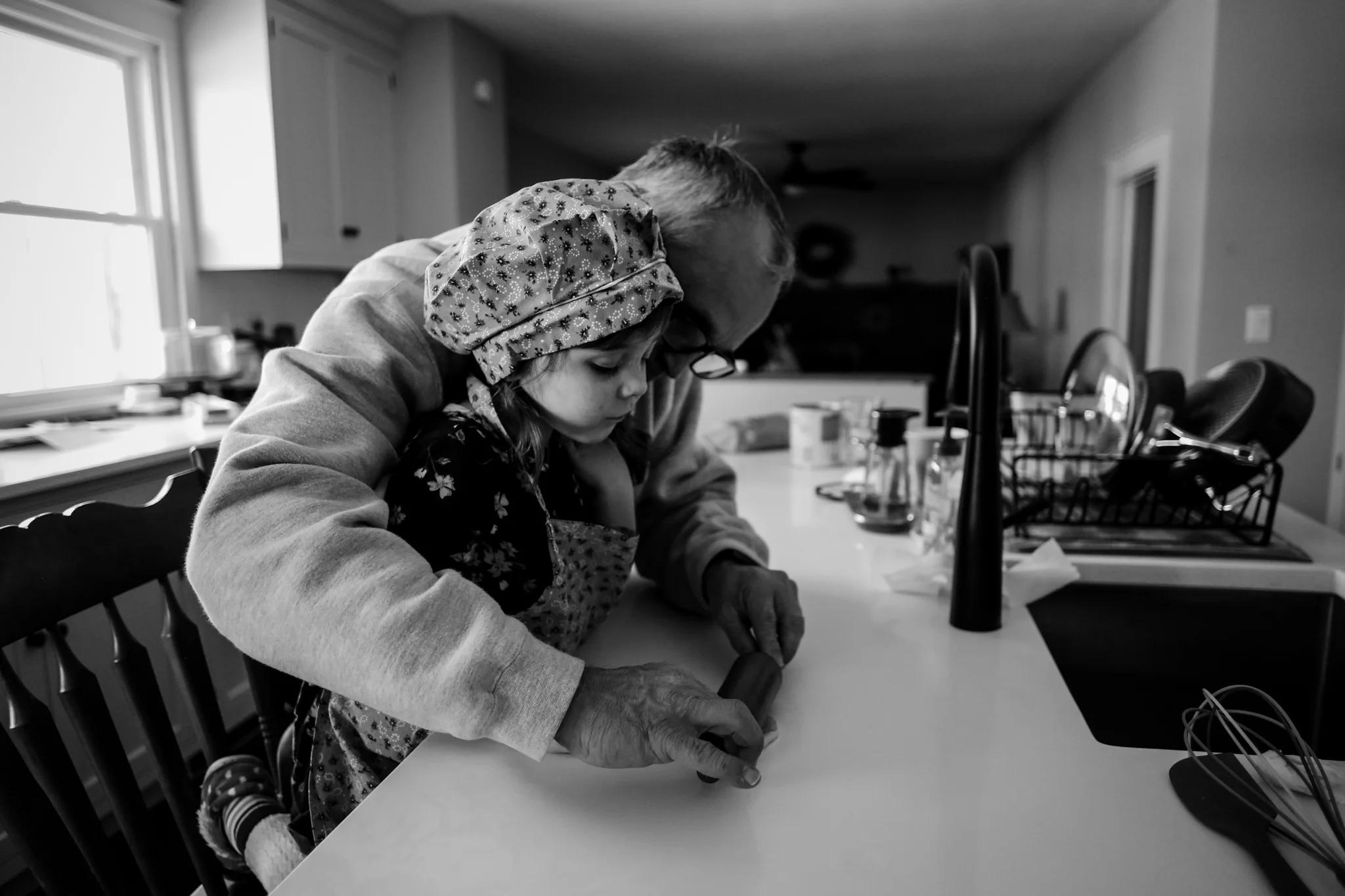 Young girl getting some help from grandpa while baking during an in home photo session with Jen Grima, Lehigh Valley family photographer.