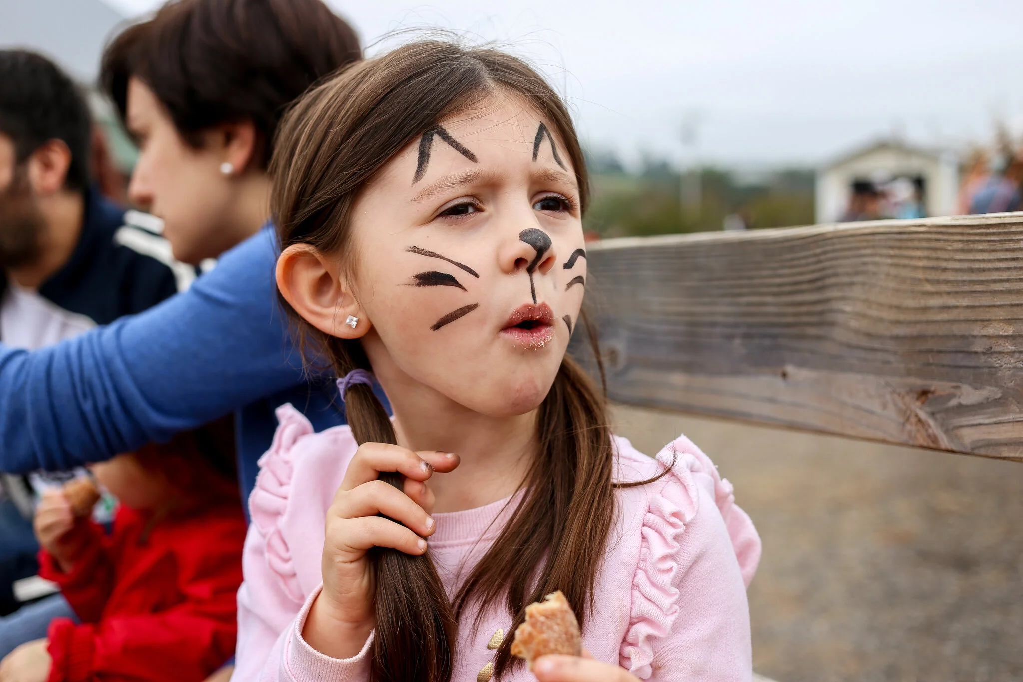 A young girl enjoys an apple cider donut on a hayride with her face painted at Hausman’s Fruit Farm in Coopersburg, PA.