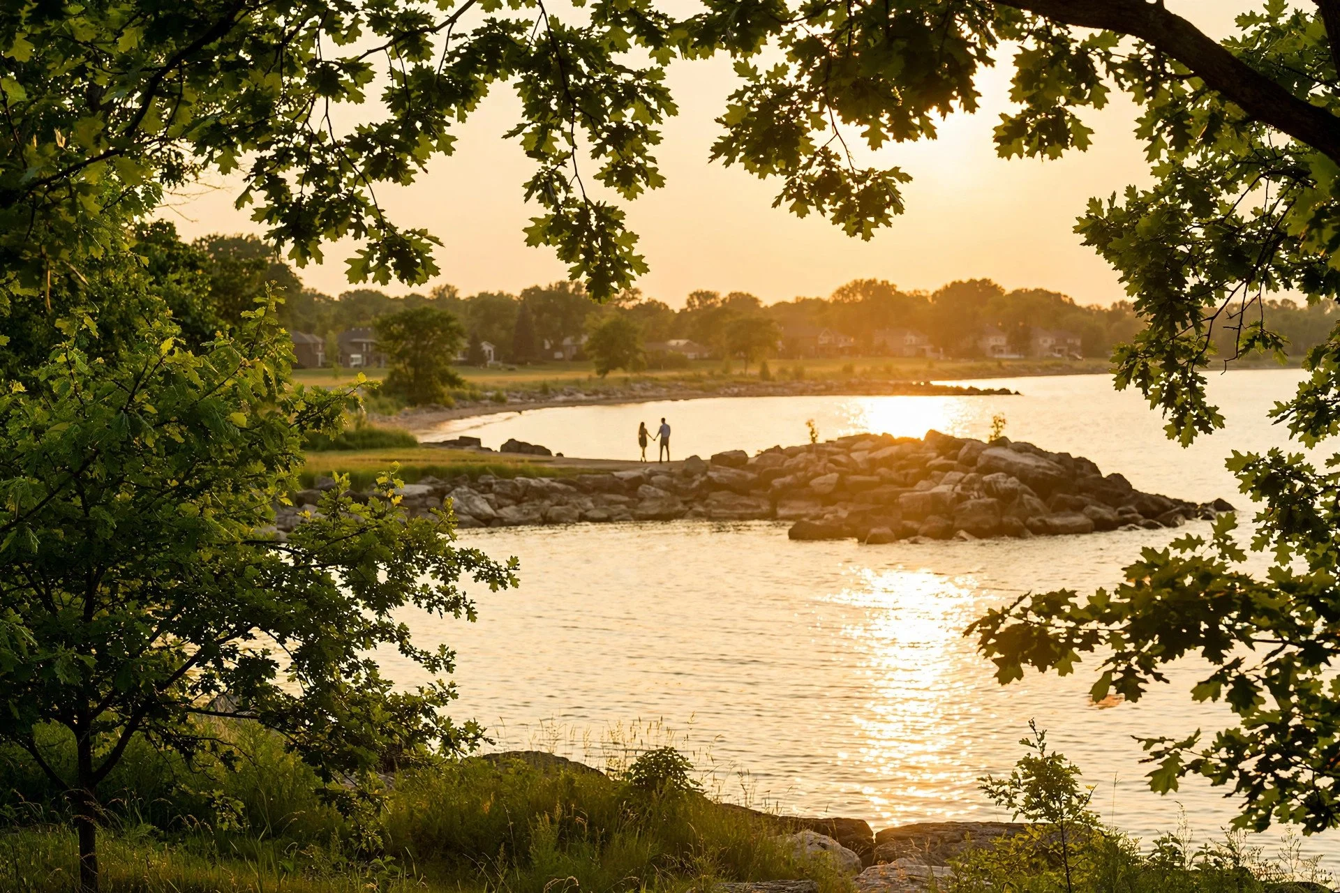 Couple on the Lake Michigan shoreline at sunset in Evanston, Illinois, framed by oak trees