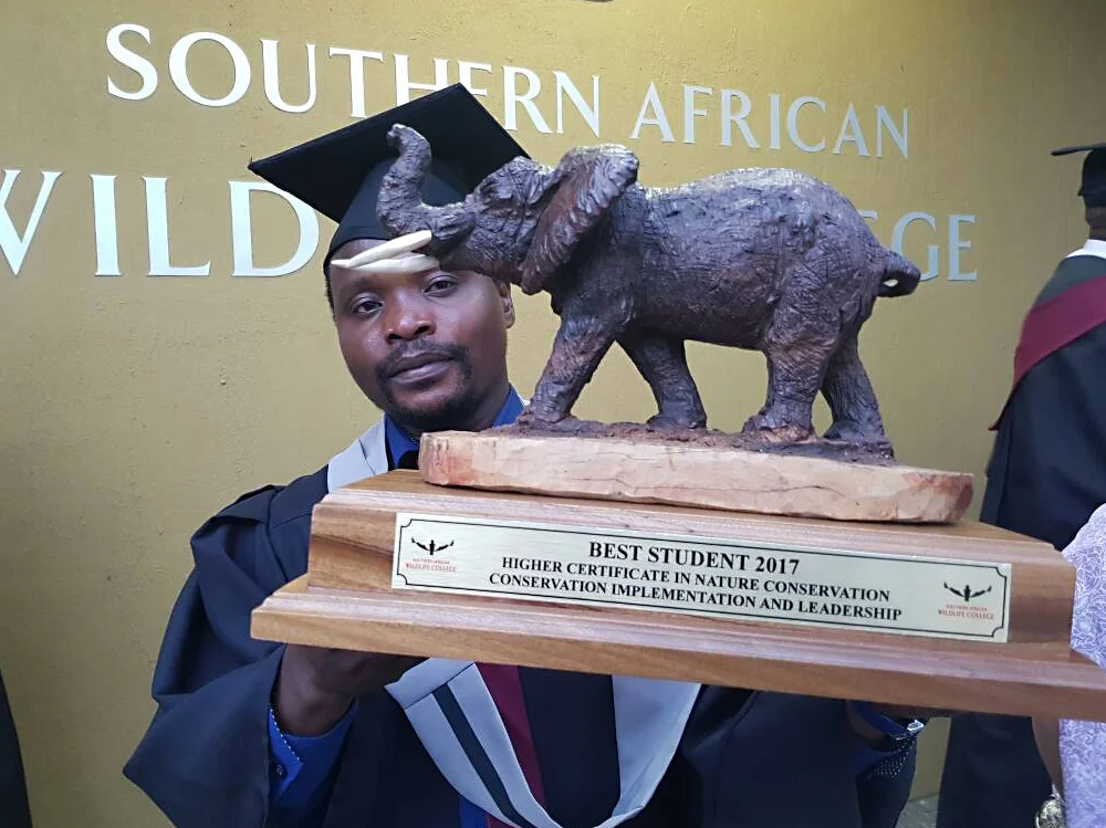 Zambian student George Phiri poses with one of several top student honors he earnedfrom his ZCP sponsorship to the Southern African Wildlife College.
