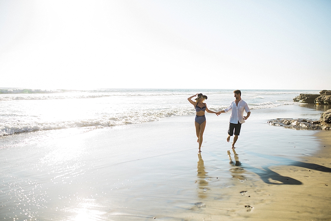 joyful couple running on del mar beach, san diego, California