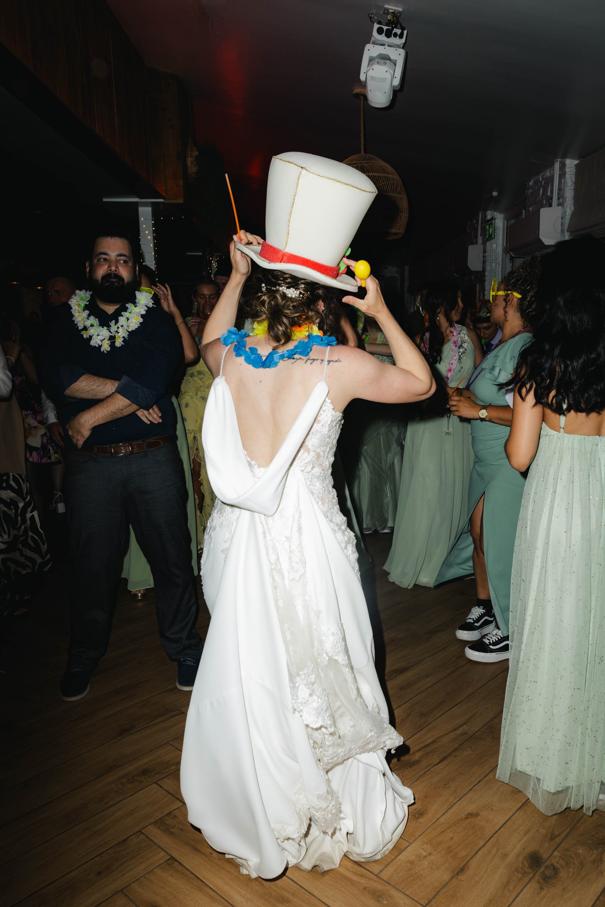 Bride wearing a silly hat on the dance floor at Watermouth Cove Weddings