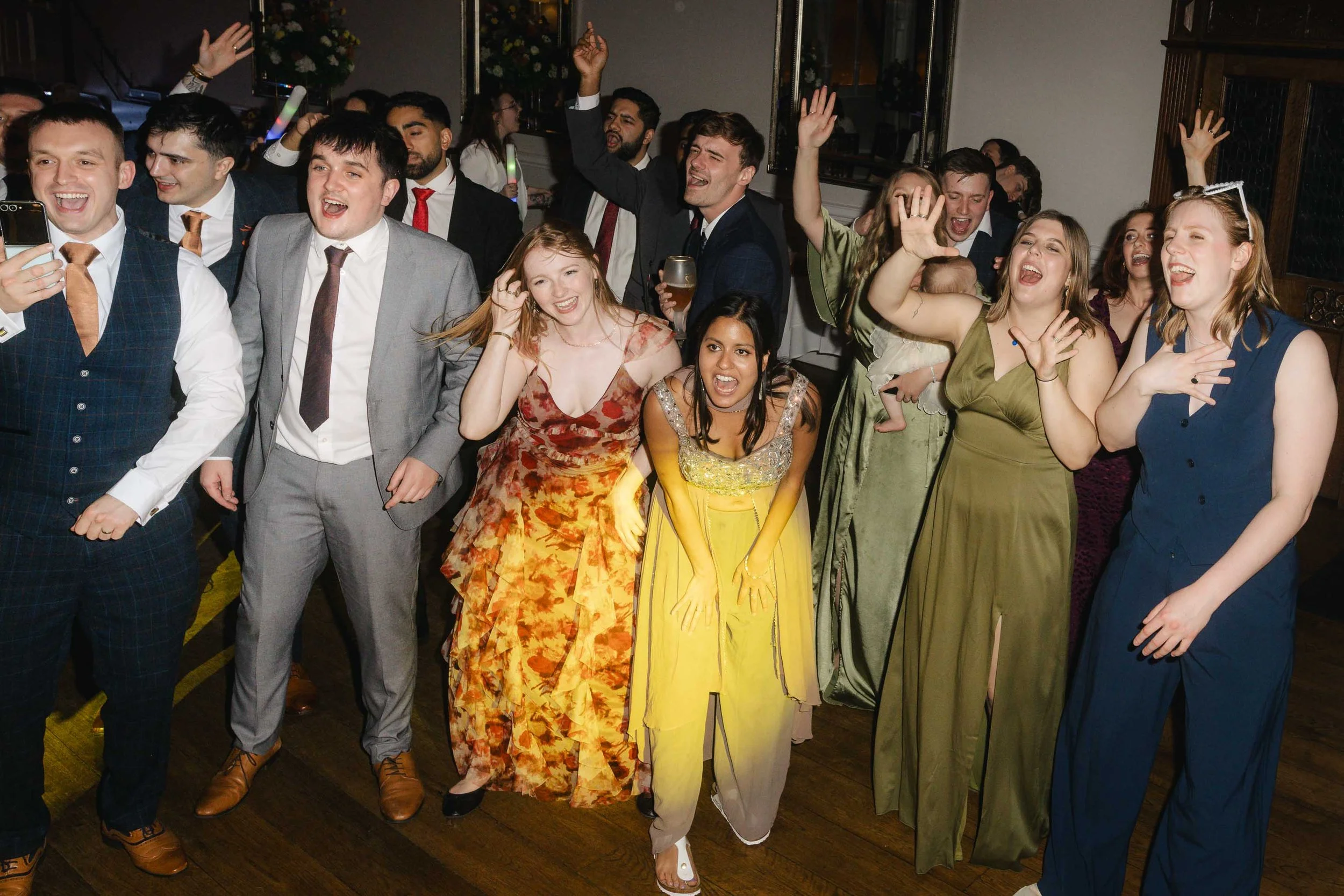Wedding guests cheering and clapping on the dance floor at Pendrell Hall.