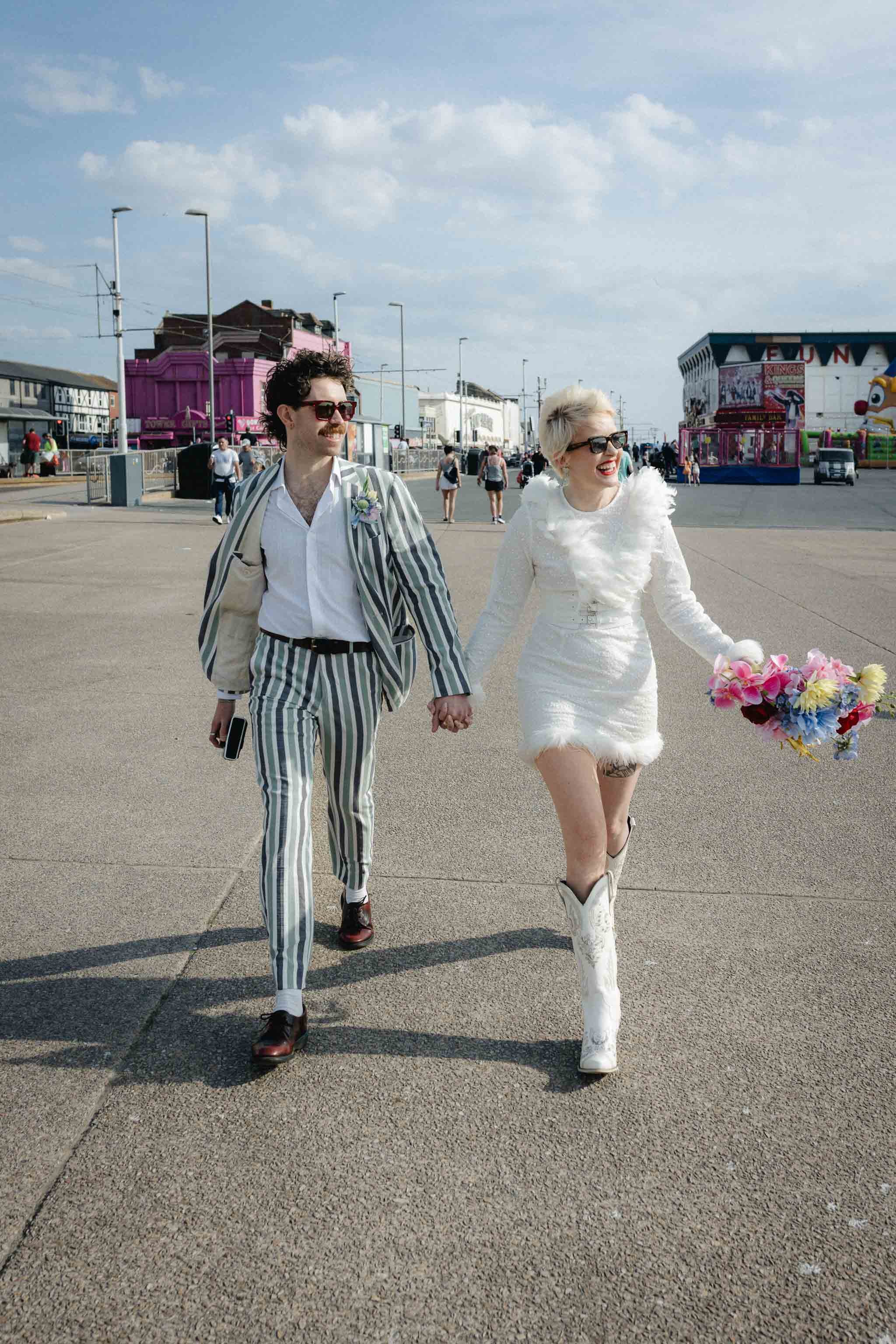 Couple walking along a seaside promenade during their intimate elopement