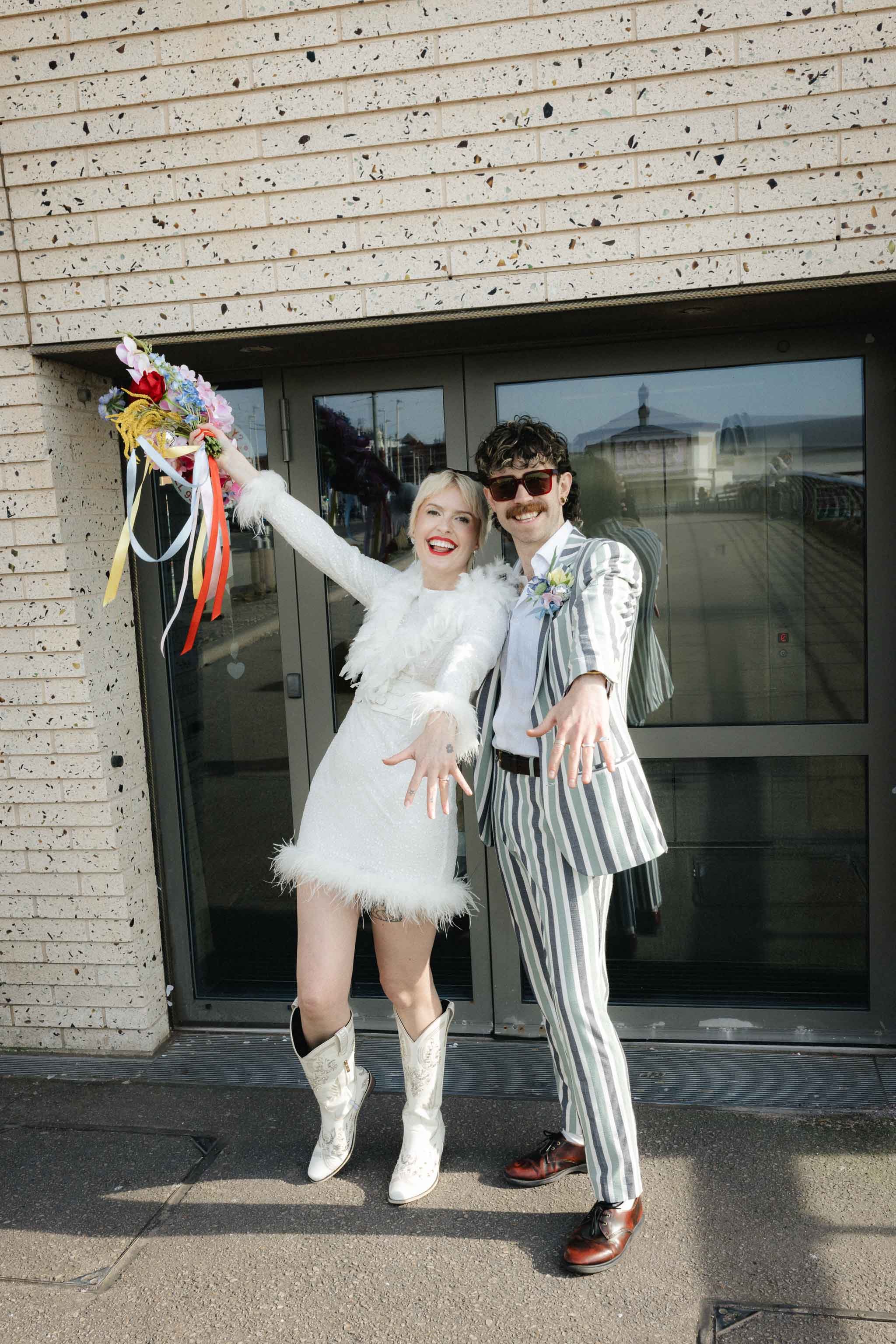 A couple stood outside Blackpool wedding chapel showing off their wedding rings