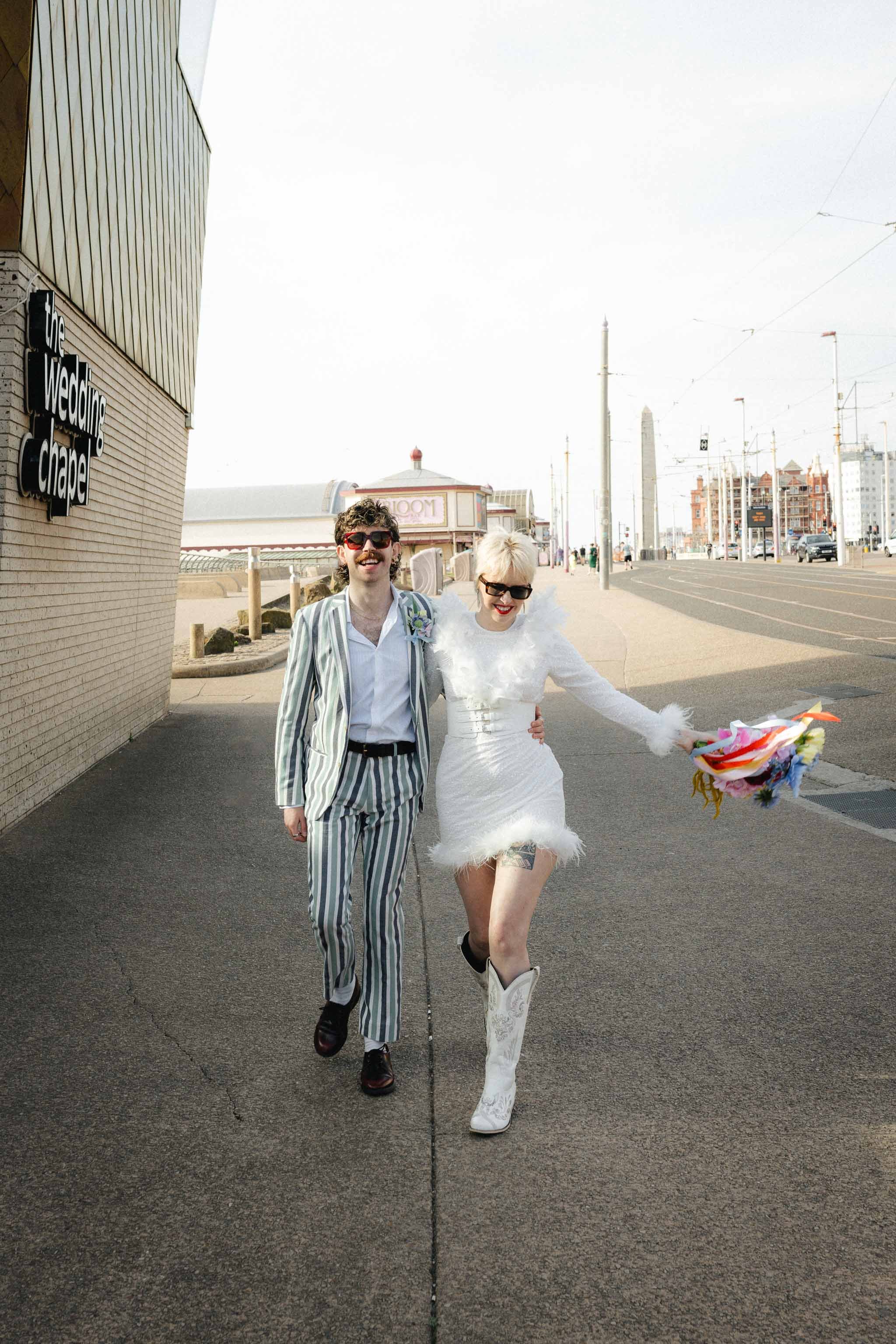 Couple walking along a seaside promenade during their intimate elopement