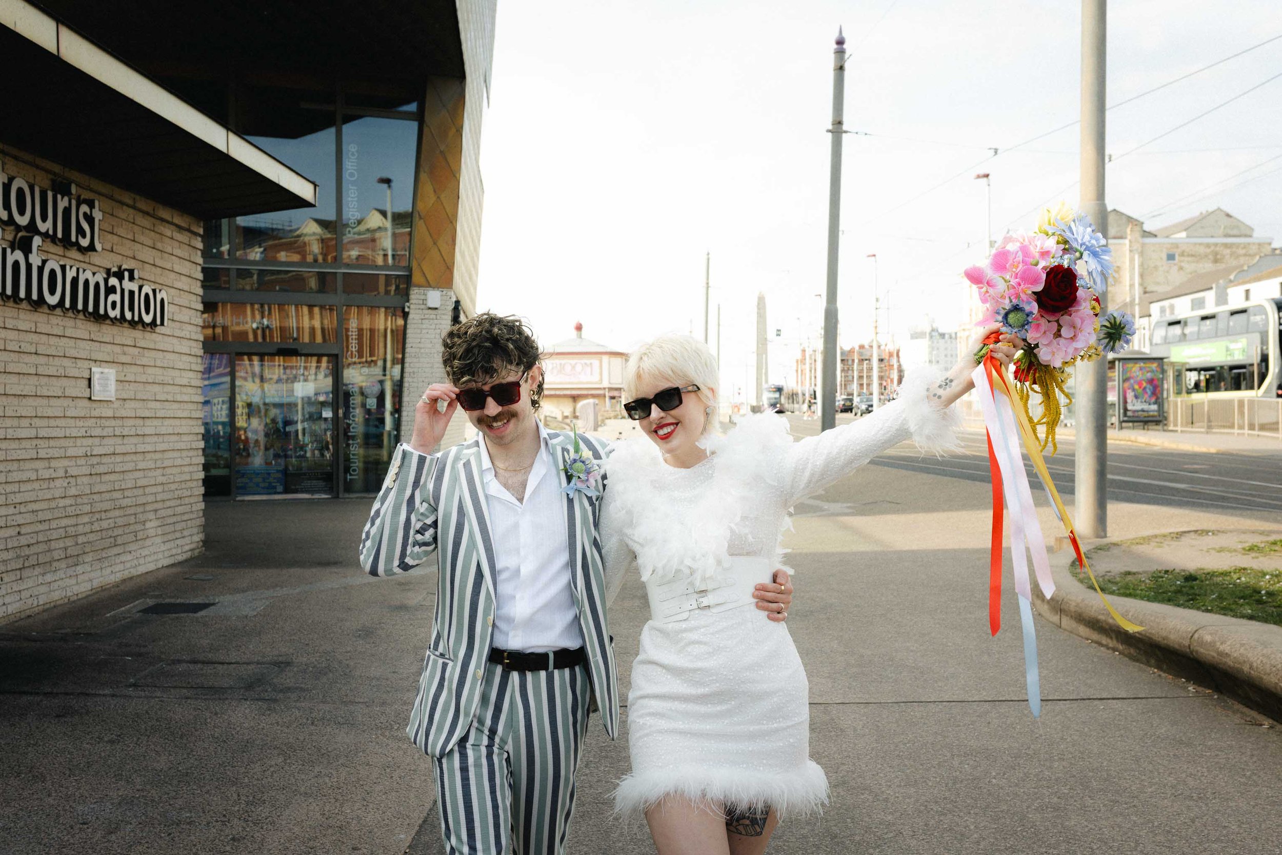 Couple walking along a seaside promenade during their intimate elopement
