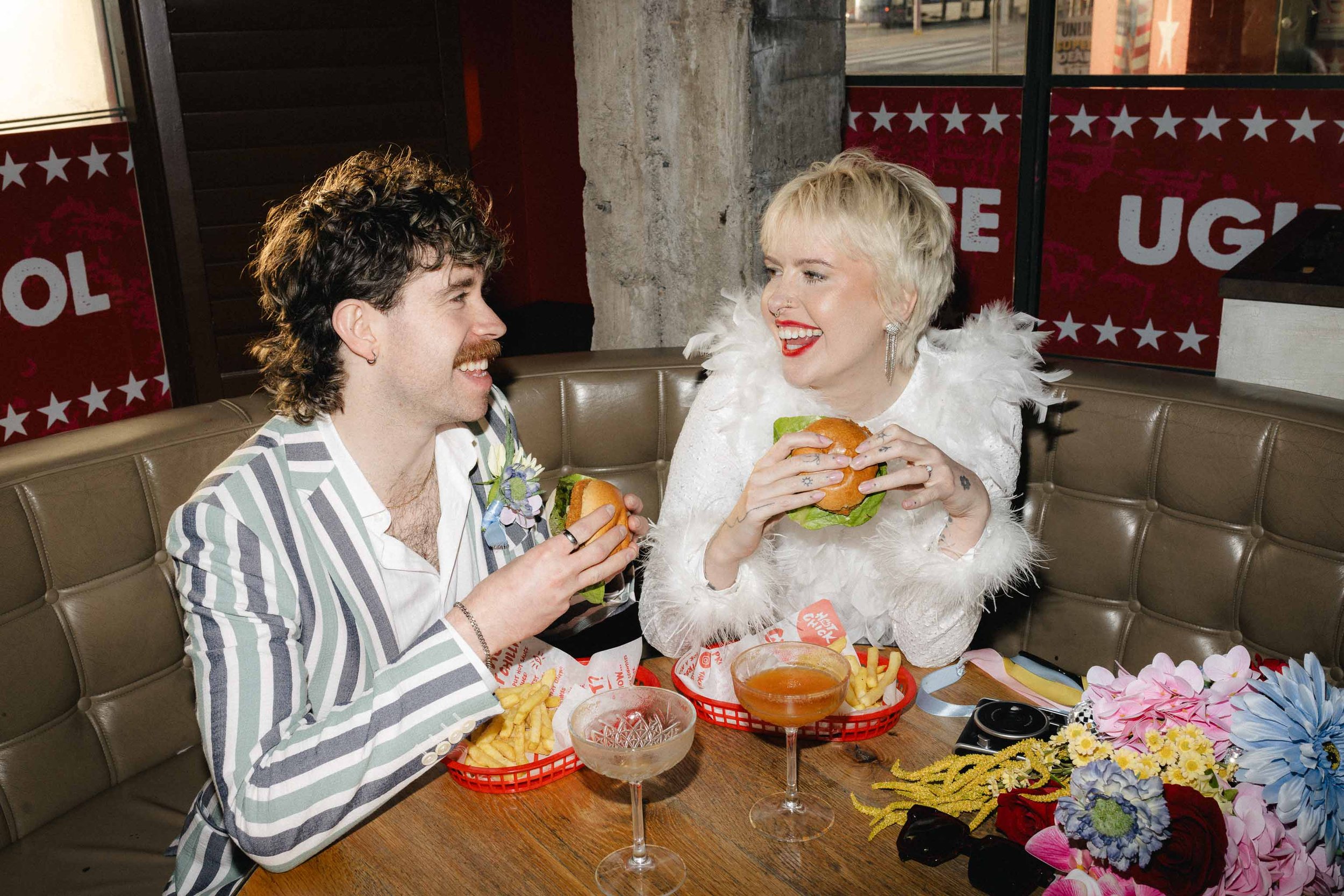 Newlyweds enjoying casual burgers and fries on their wedding day
