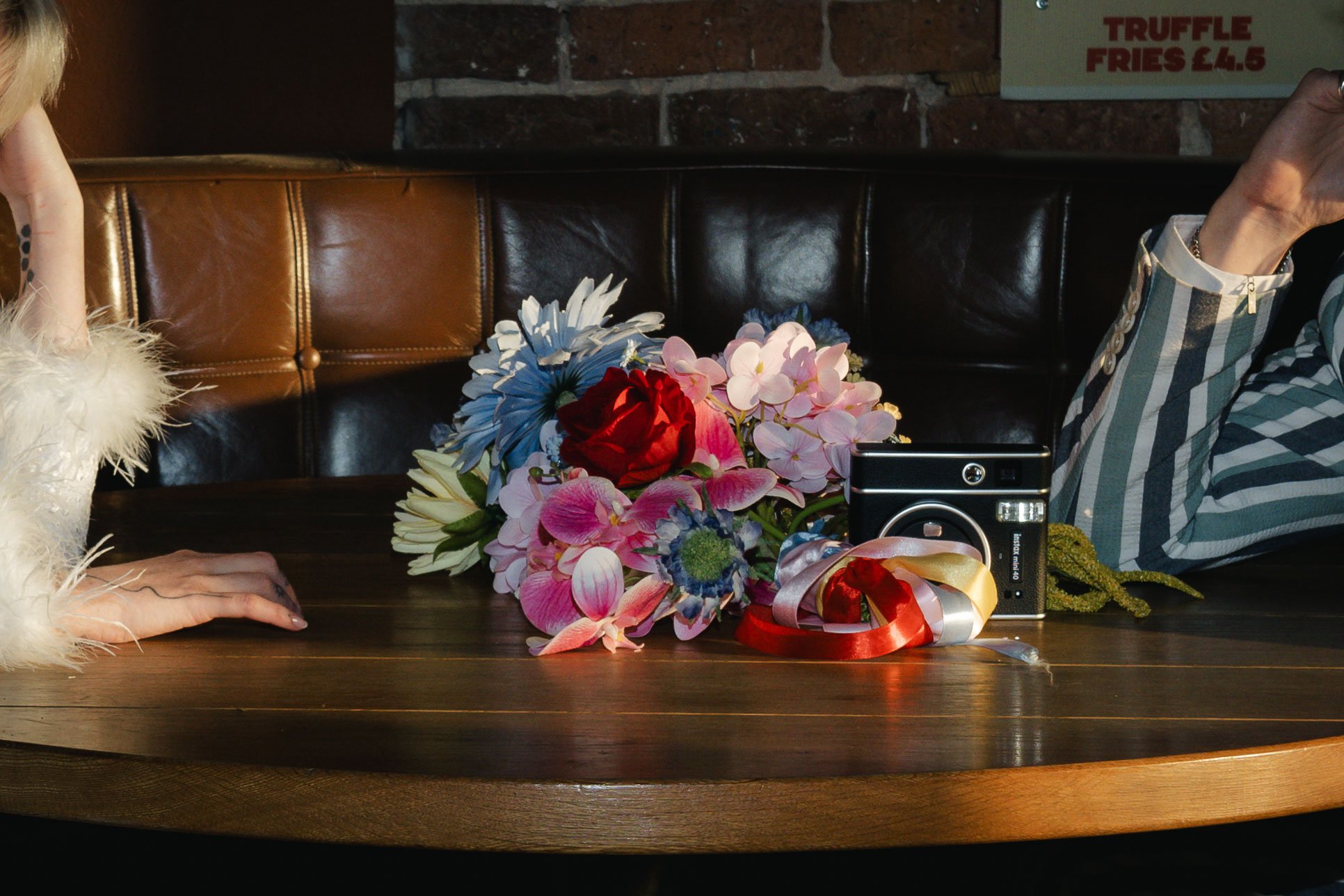 Editorial close up of a bride's brightly coloured bouquet in a pool of sunlight