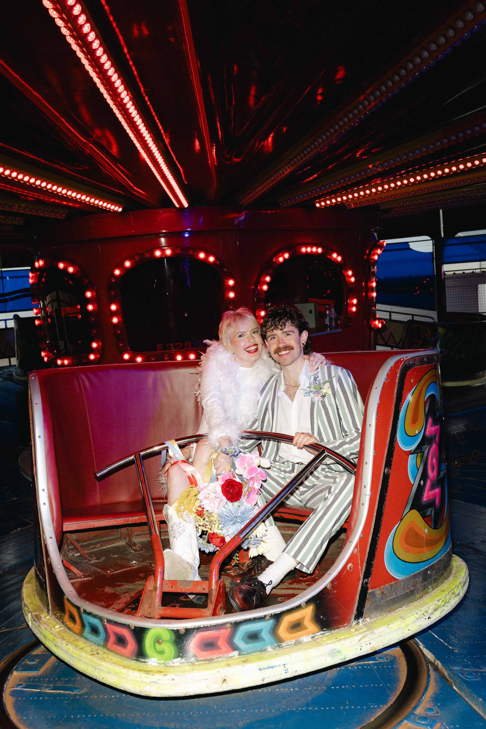 Bride and groom having fun on a vintage fairground ride during their wedding