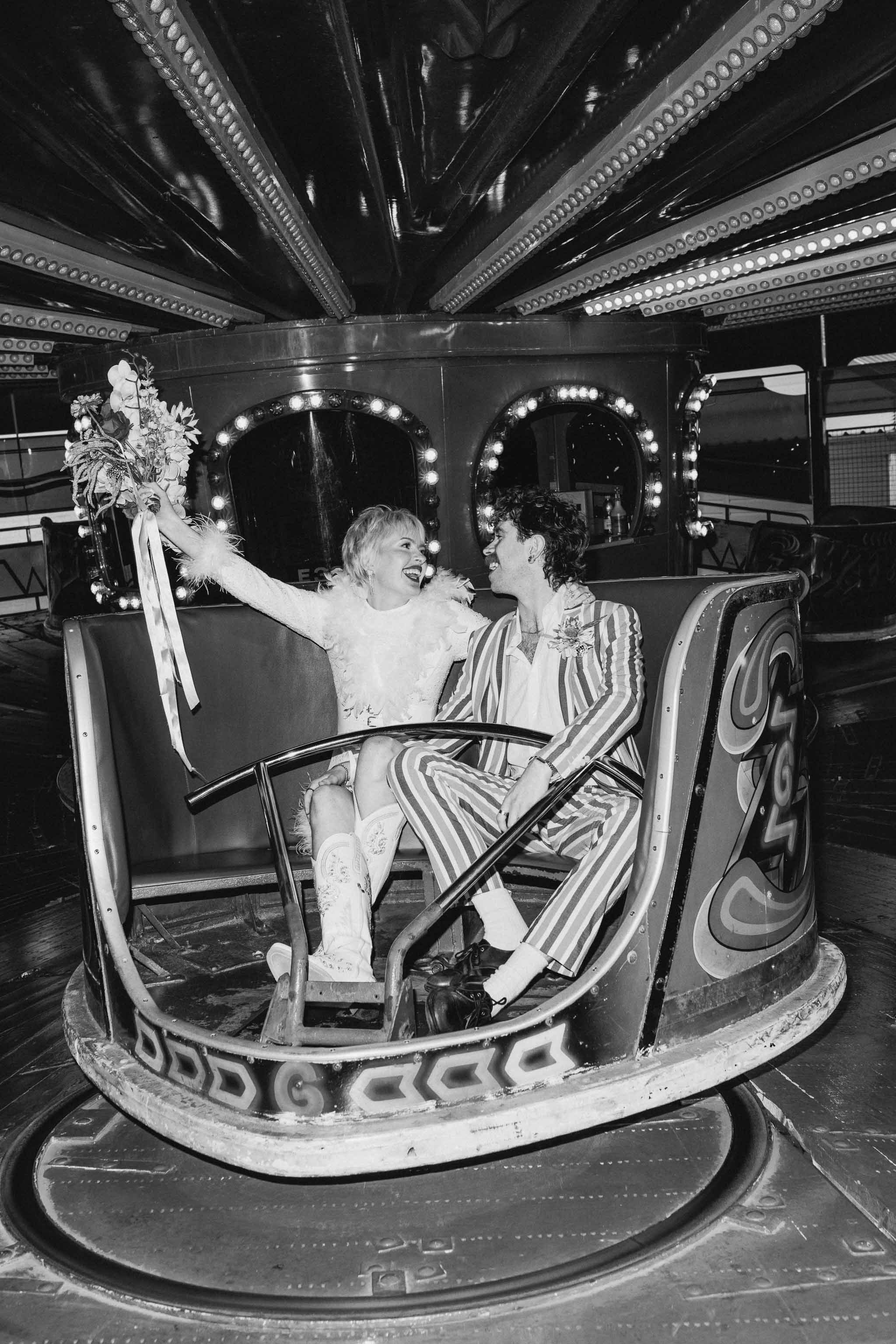 Bride and groom having fun on a vintage fairground ride during their wedding