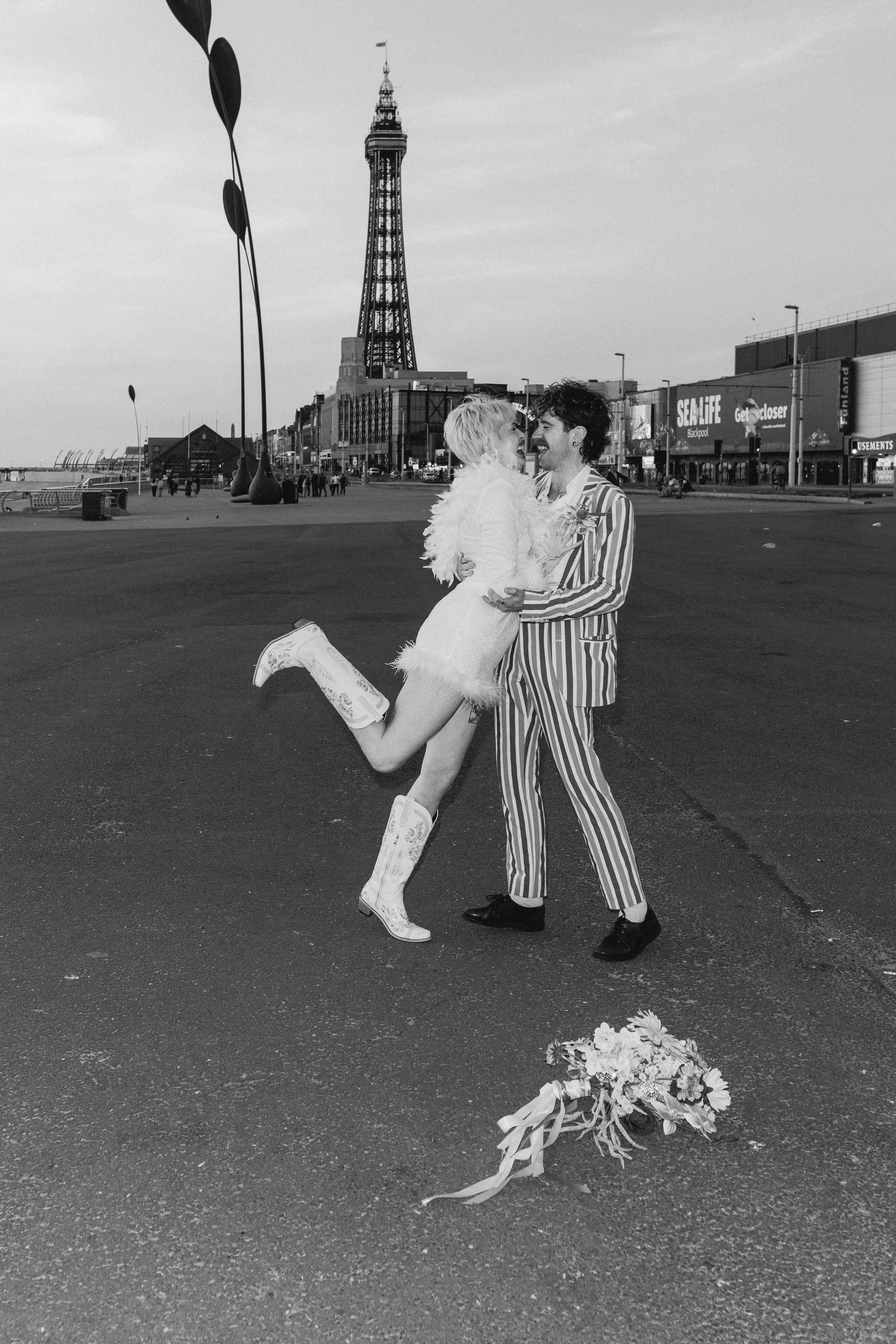 Copule kissing on their wedding day in front of Blackpool Tower