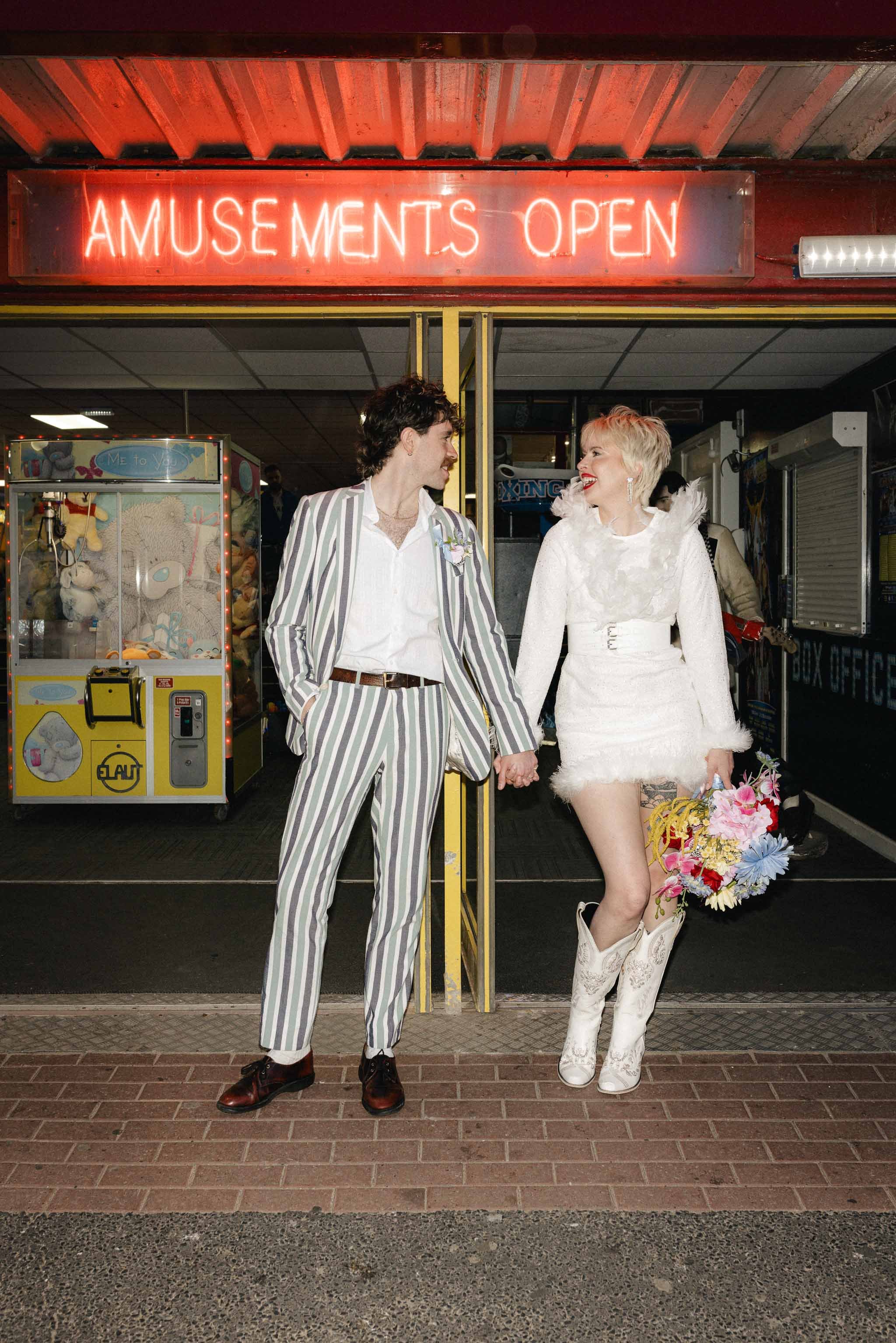 Newlywed couple laughing outside an amusement arcade during their elopement