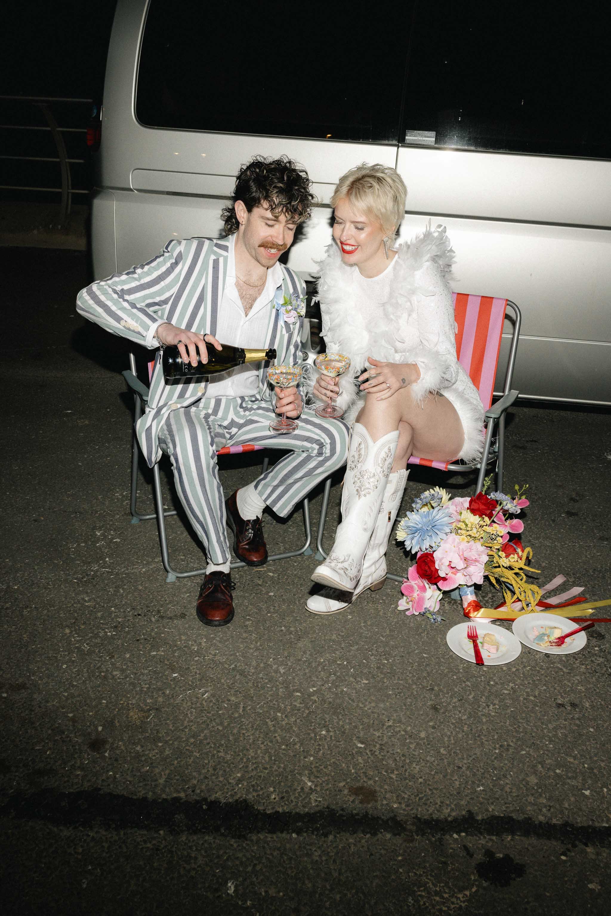 Bride and groom drinking champagne infant of their camper van on Blackpool sea front