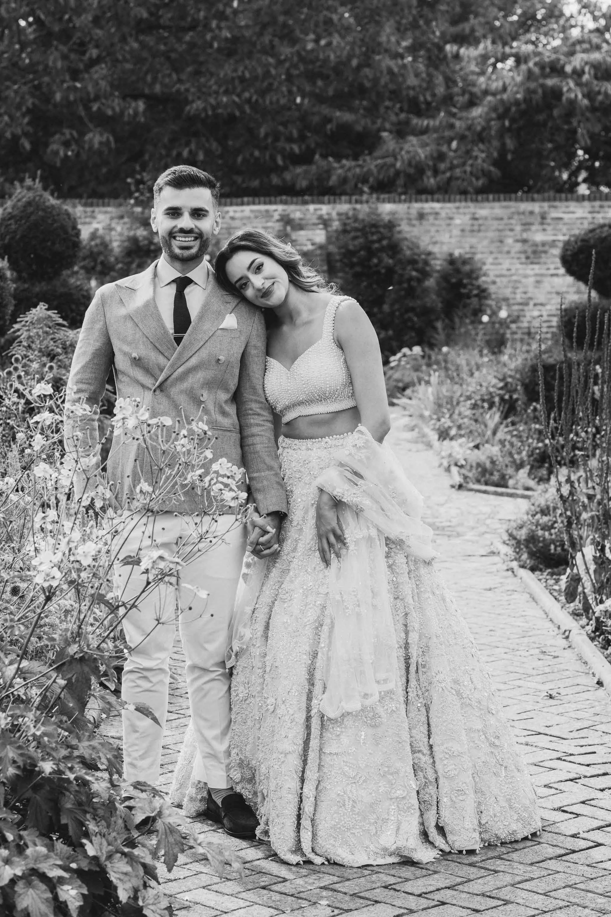 Romantic engagement photo, couple side by side with garden backdrop.