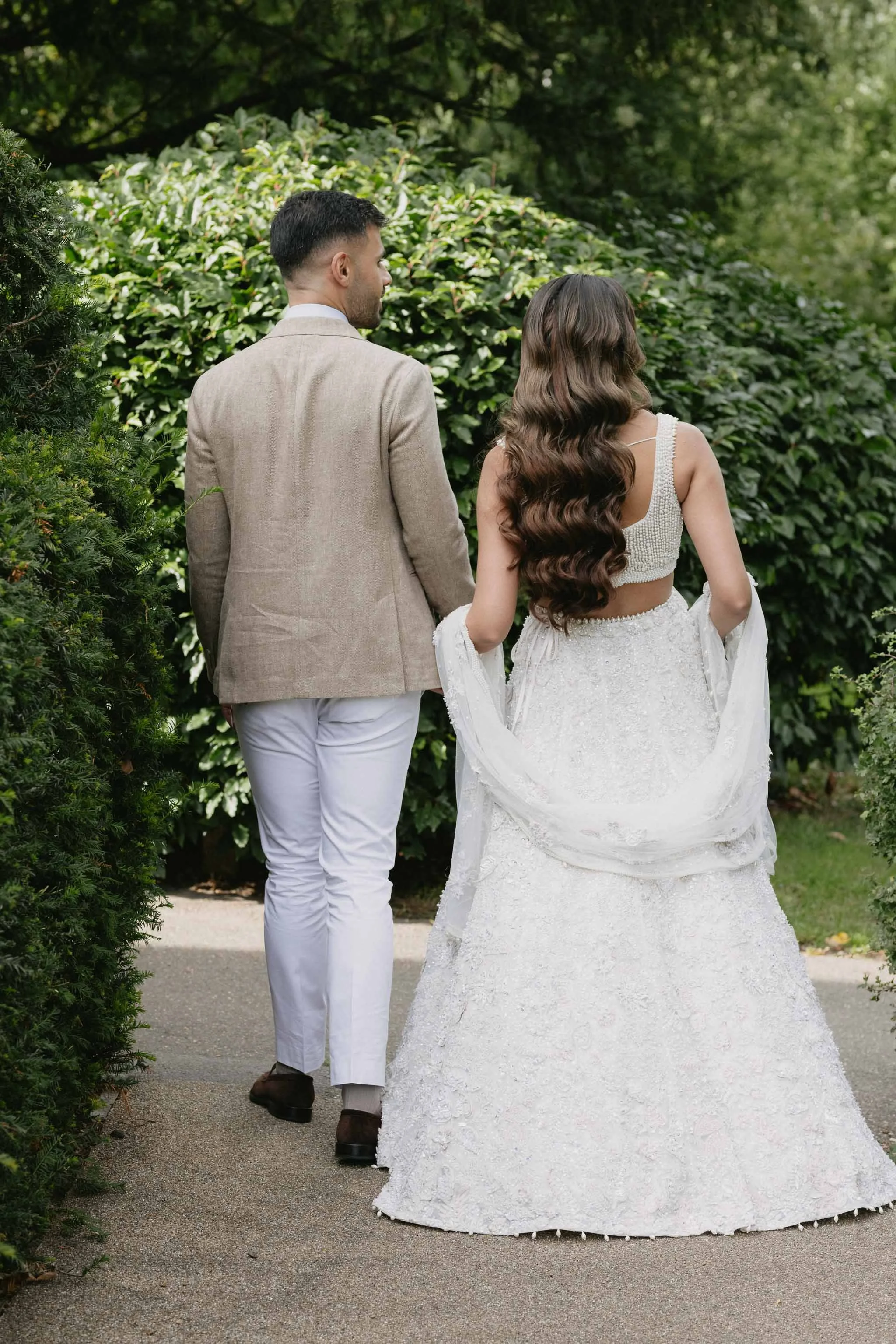 Editorial engagement photo - couple strolling naturally through Buckinghamshire gardens