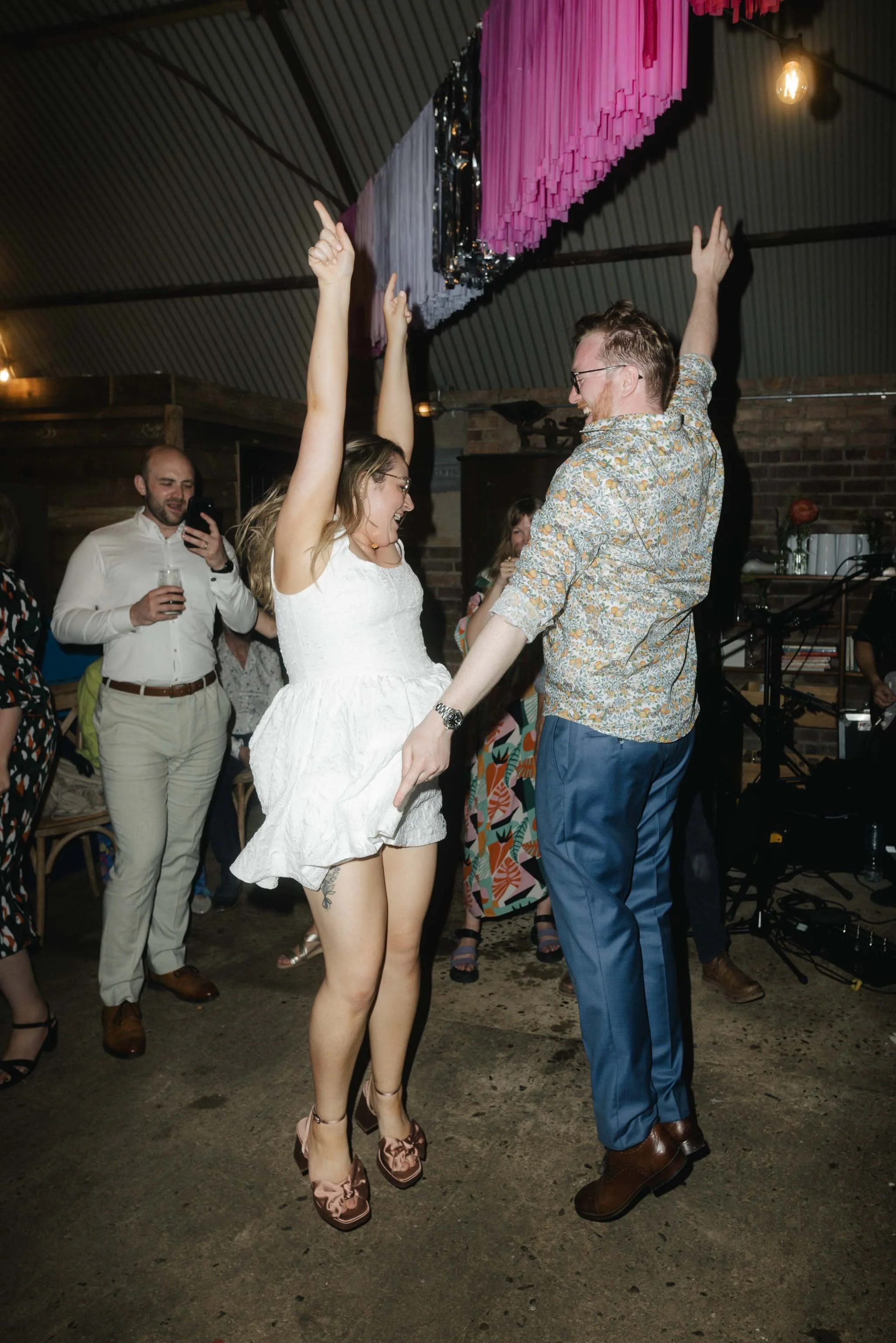  Bride and groom jumping in the air on the dance floor. 