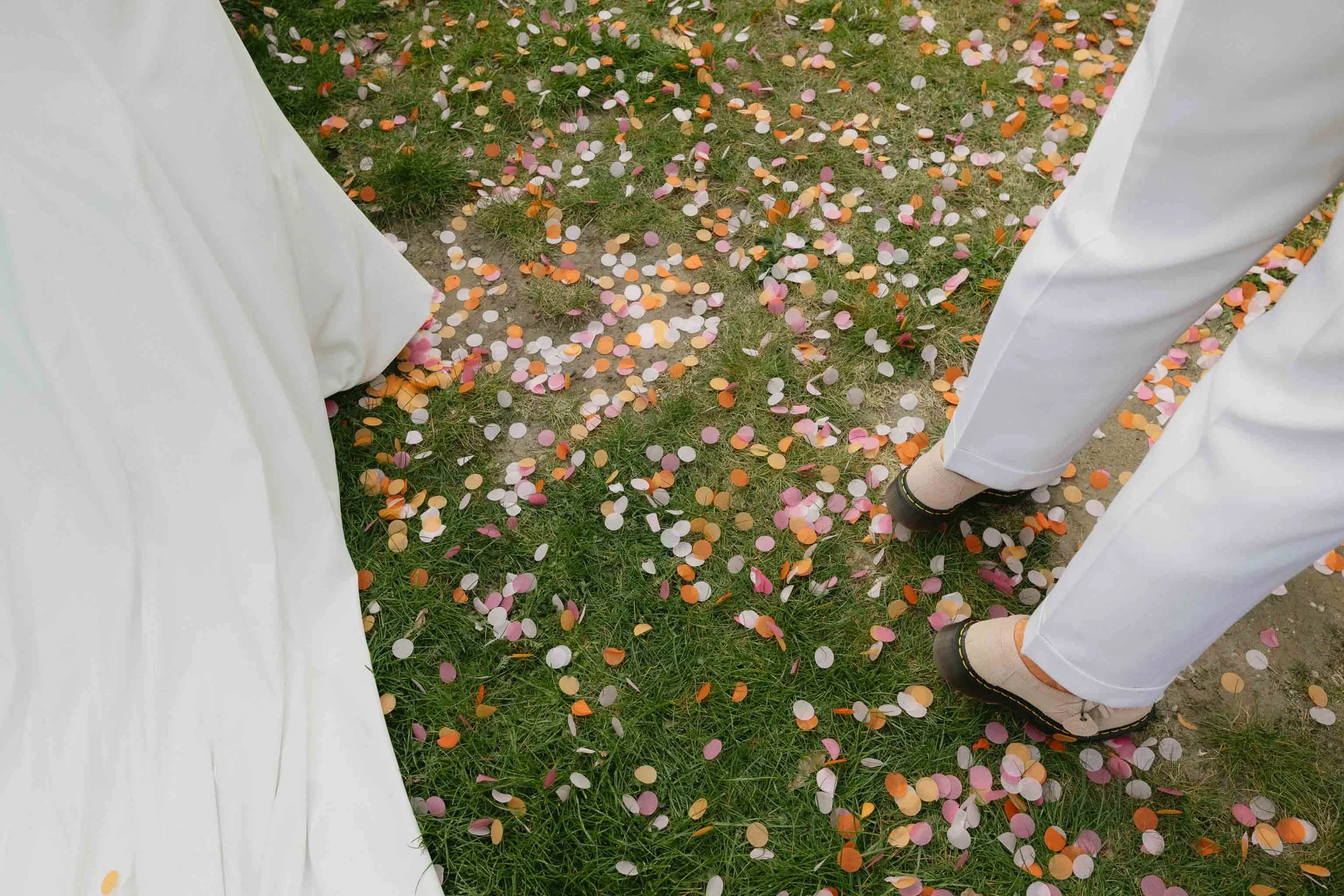  Storytelling photo of confetti on the ground by the couple’s feet. 