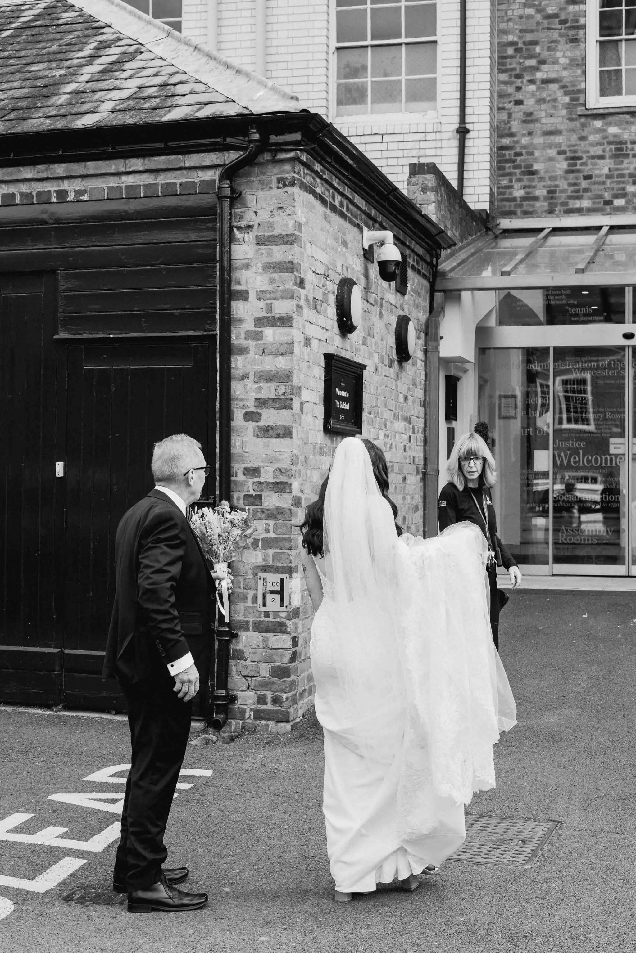  Black and white photo of a bride walking into Worcester Registry Office. 