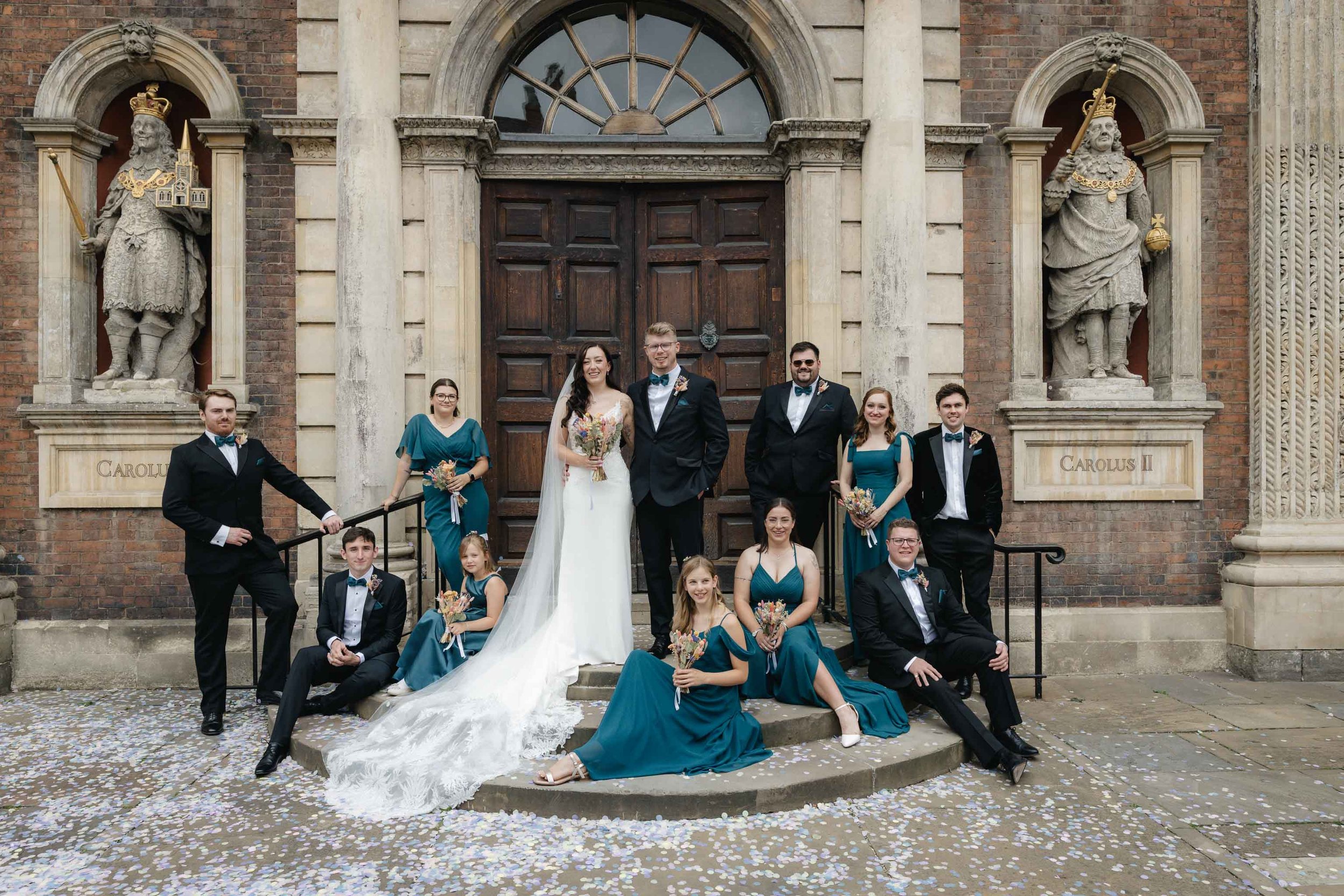 Editorial wedding party shot with bridesmaids and groomsmen sat on steps outside Worcester Guildhall. 