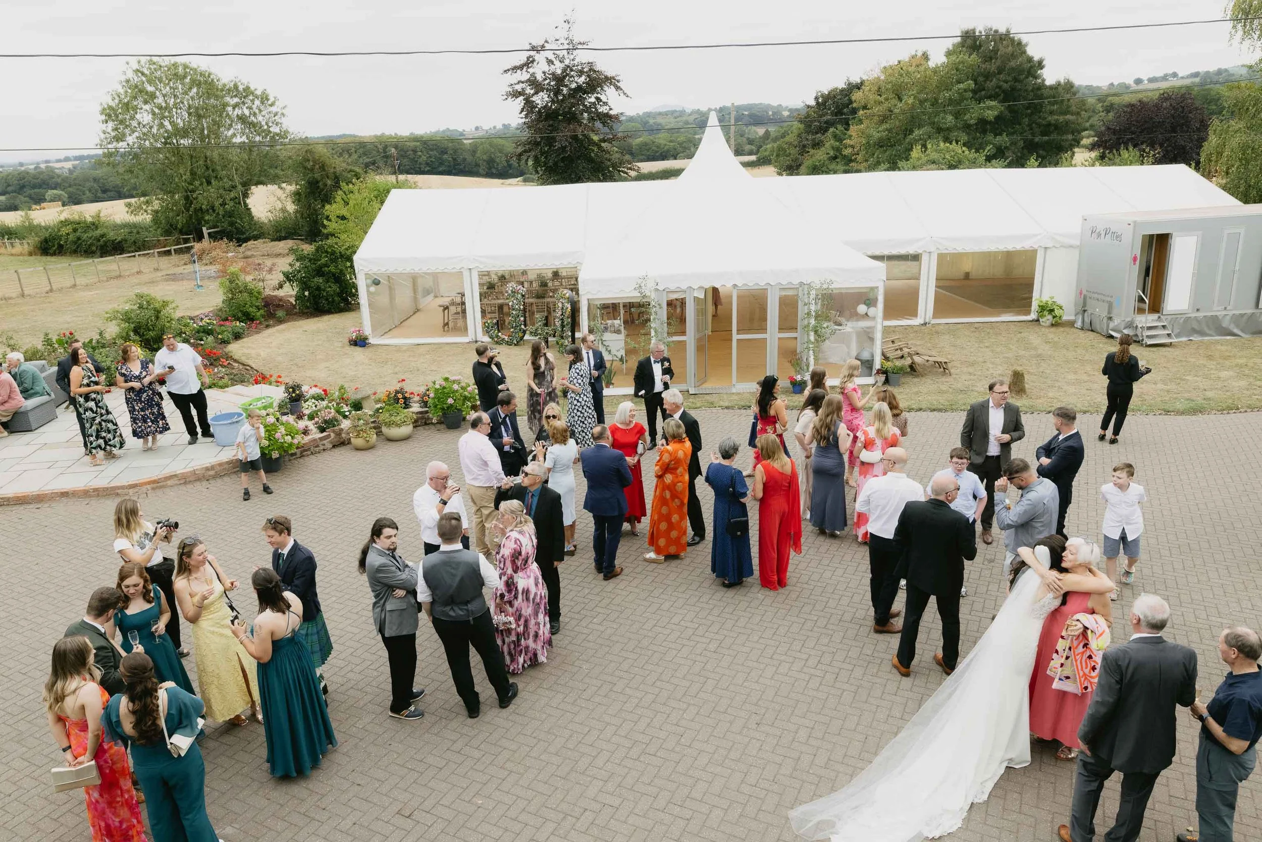  Bride greets guests outside a marquee wedding reception in Worcester. 
