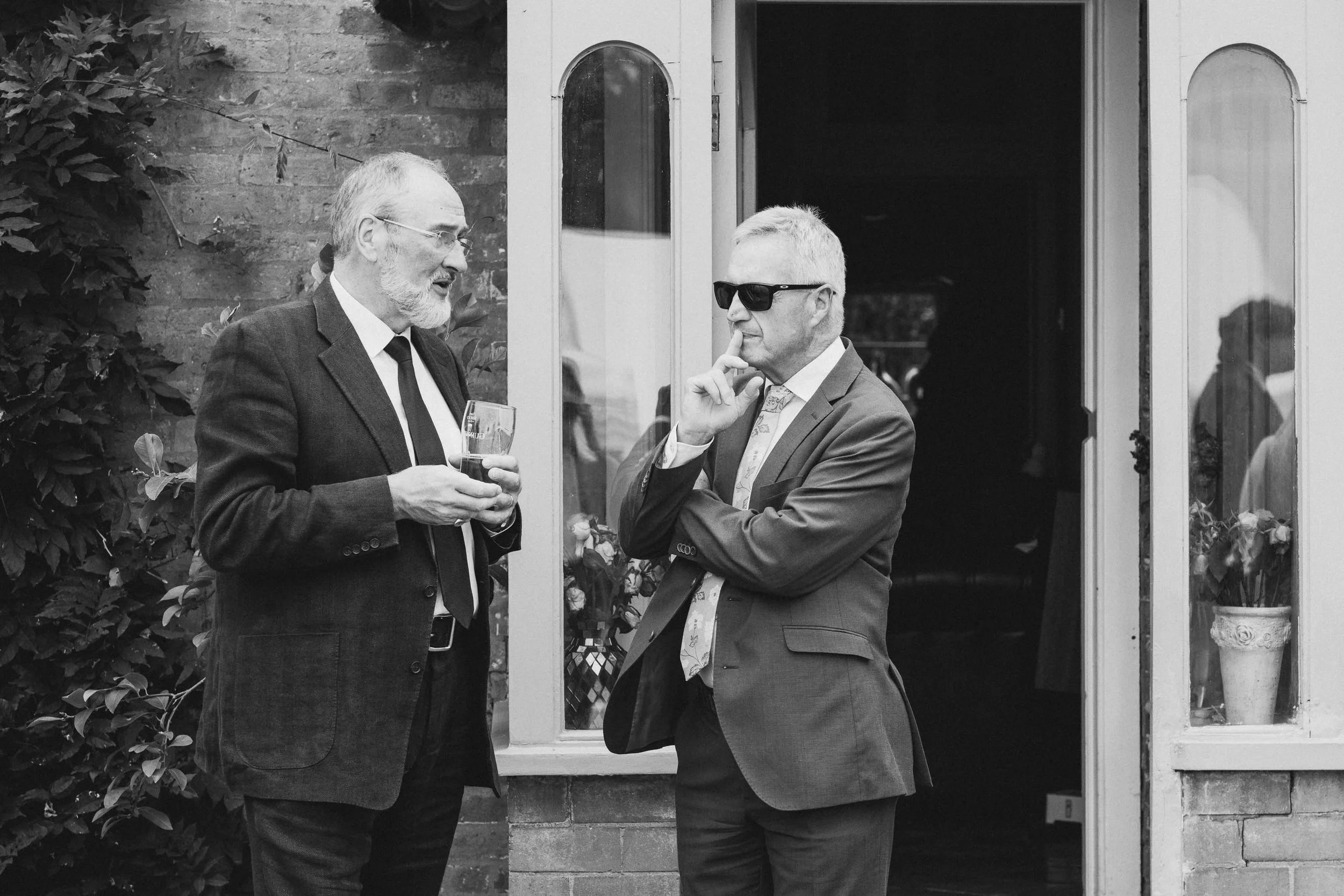  Two male guests deep in thought at a Worcester wedding reception at home.  