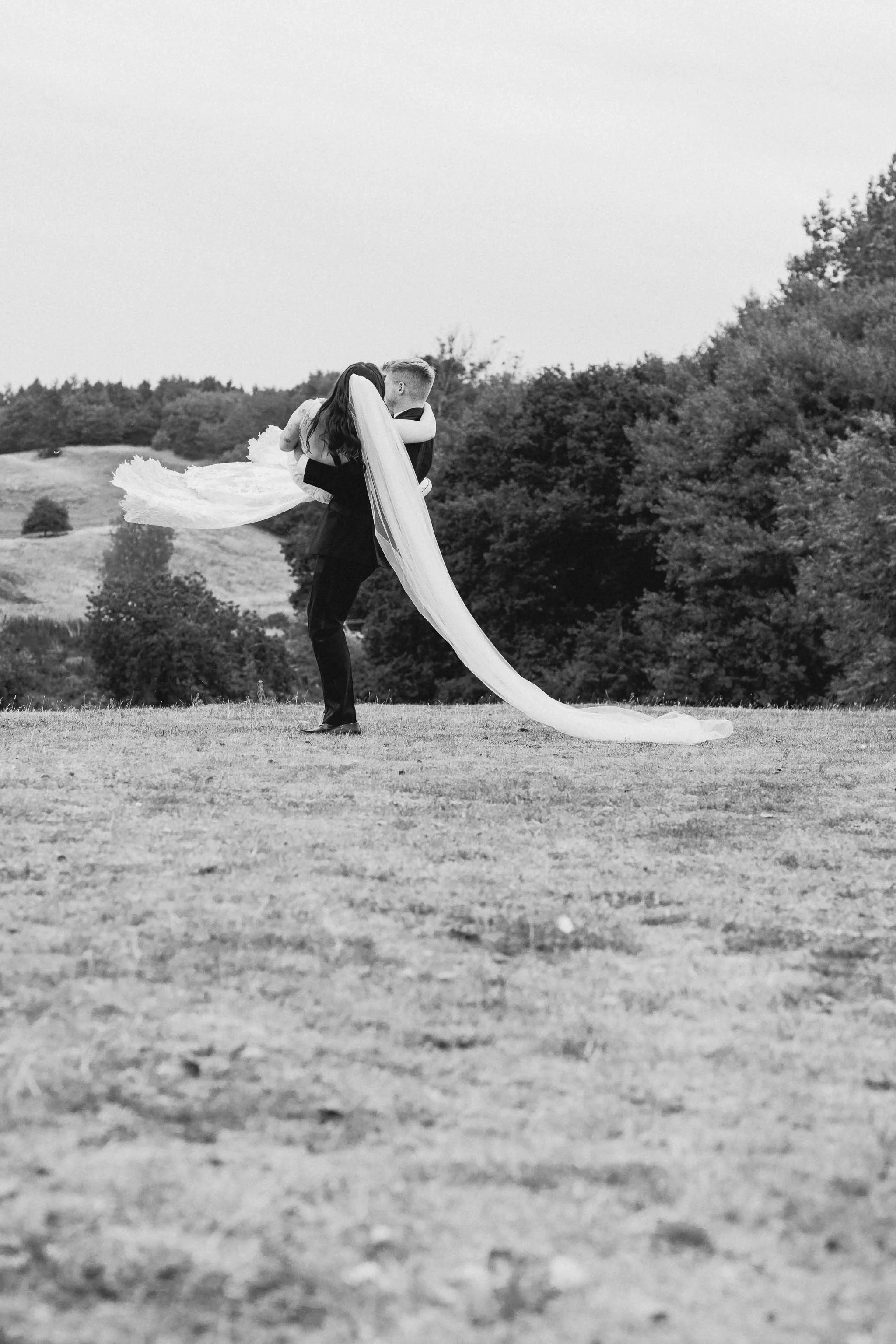  Newlywed couple spinning around in a field at a home wedding reception in Worcester. 
