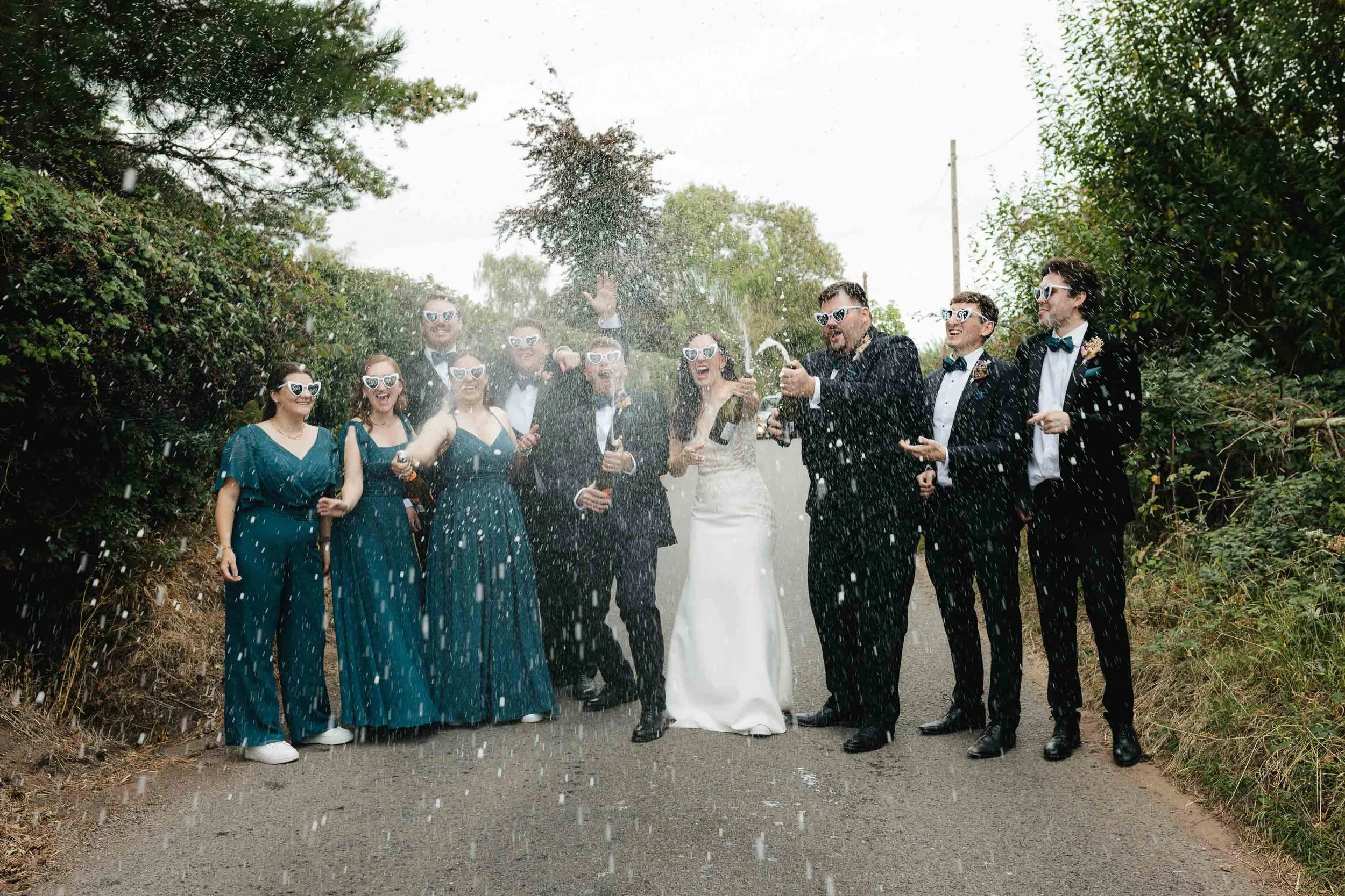  Bridal party champagne moment during Jess + Oli’s marquee wedding reception in Worcester.   