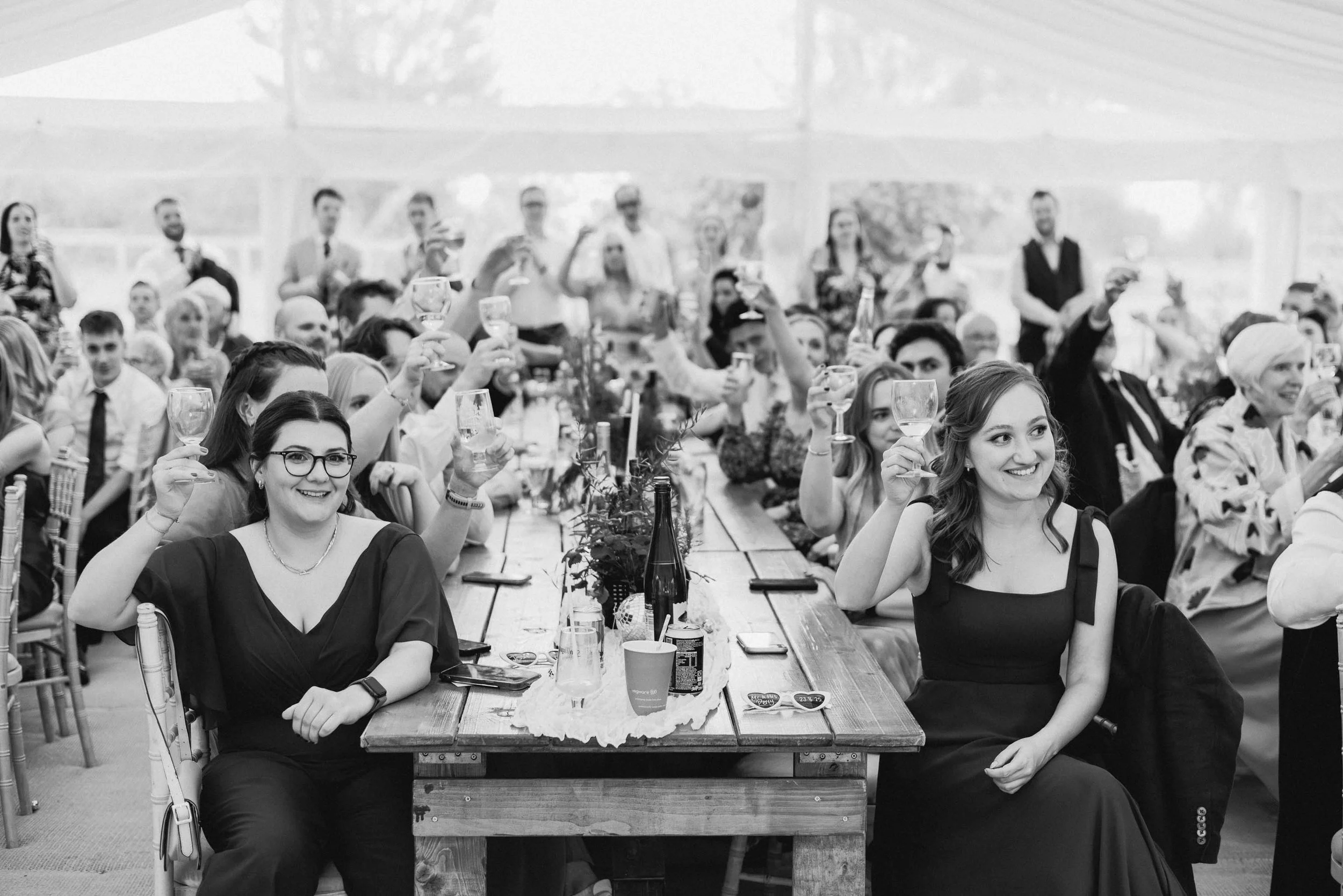  Wedding guests sat in a marquee cheering. 