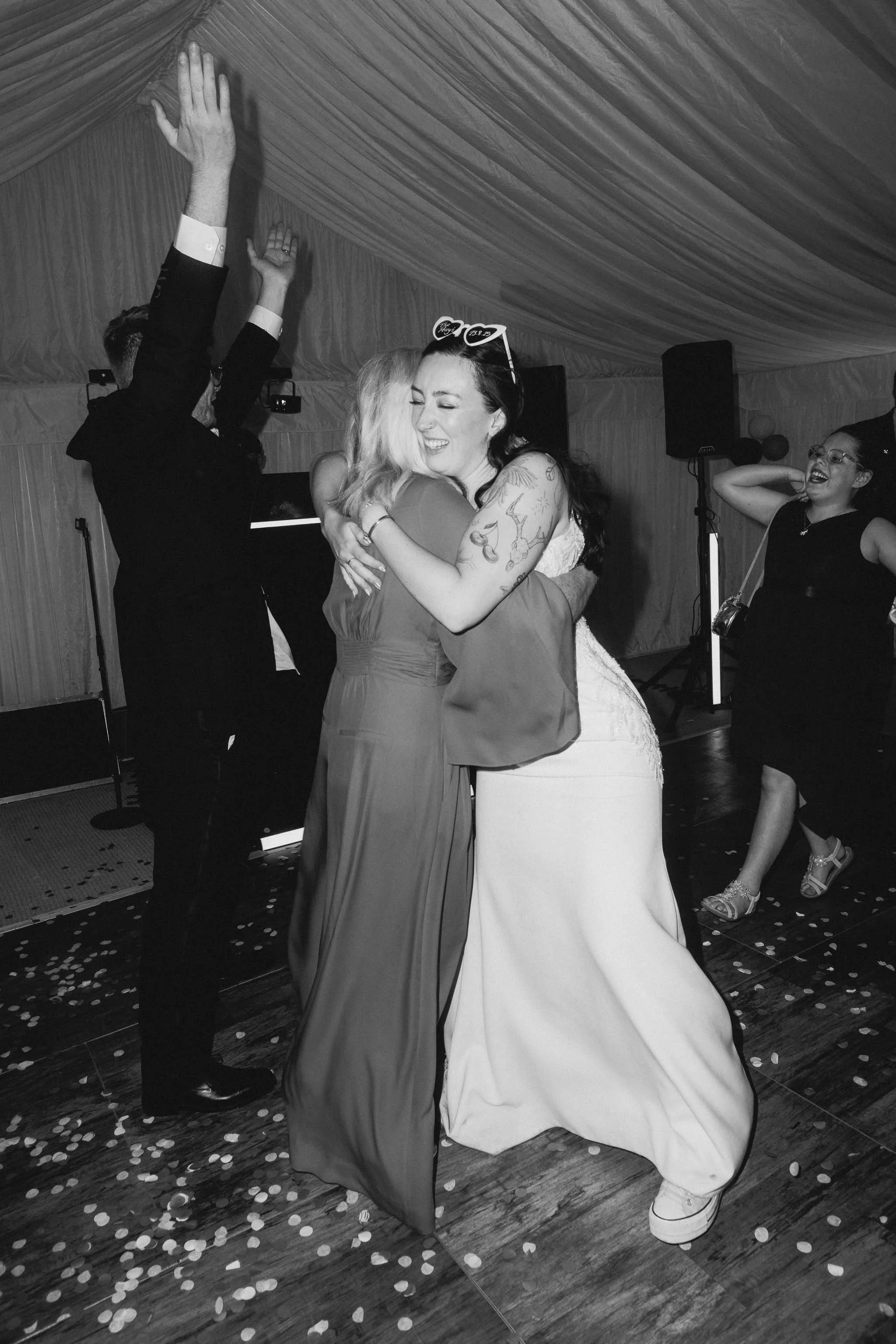  Bride hugging a guest at backyard wedding reception in Worcester. 