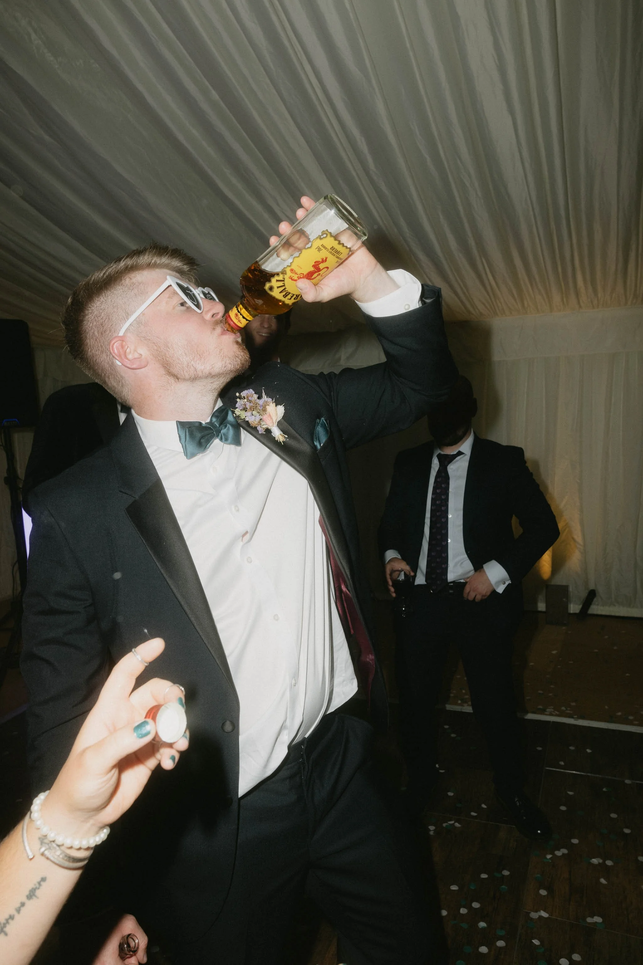  Groom drinking from a bottle on the dance floor at a backyard wedding reception in Worcester. 