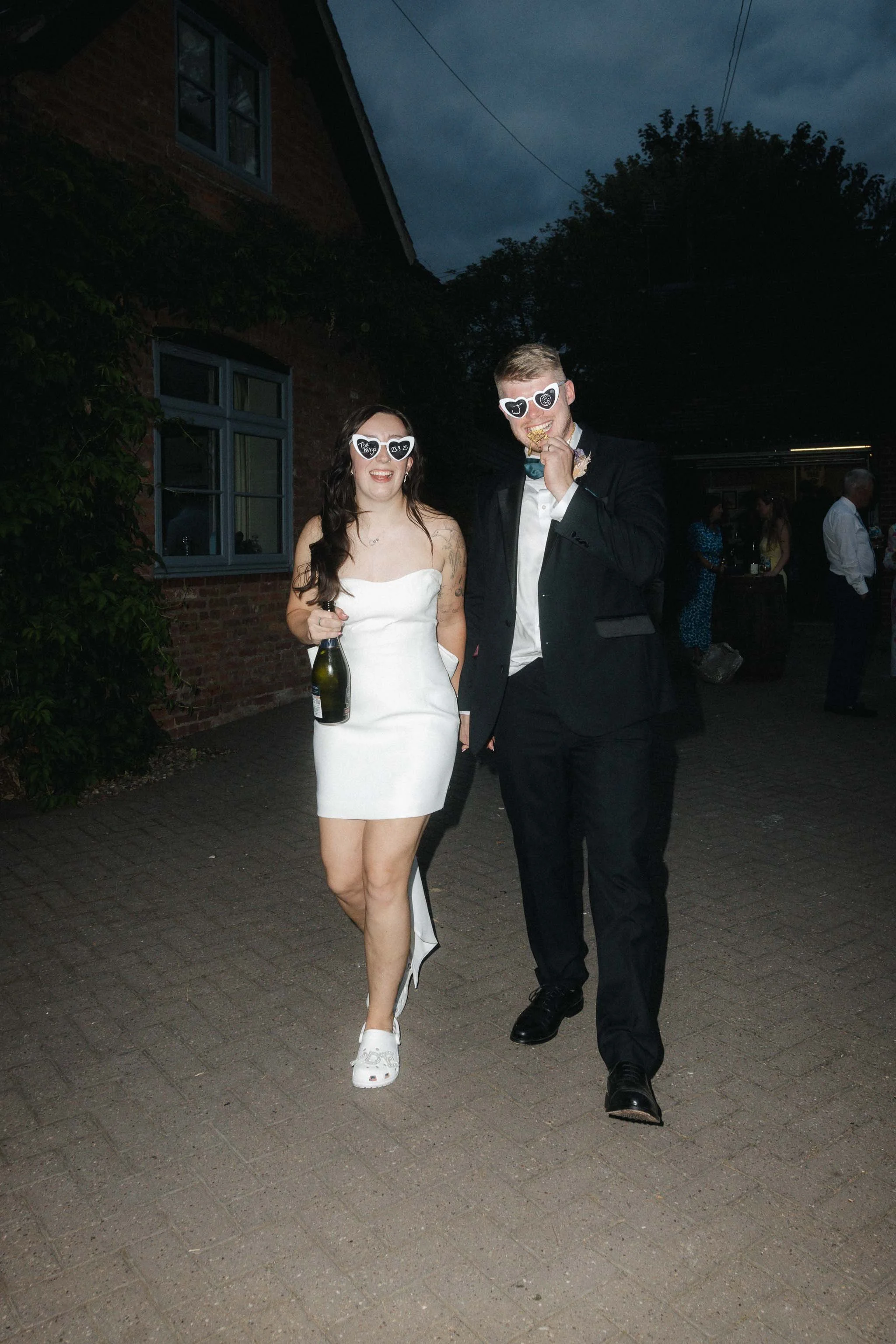  Jess + Oli walking together at night for editorial wedding portraits in Worcester.   