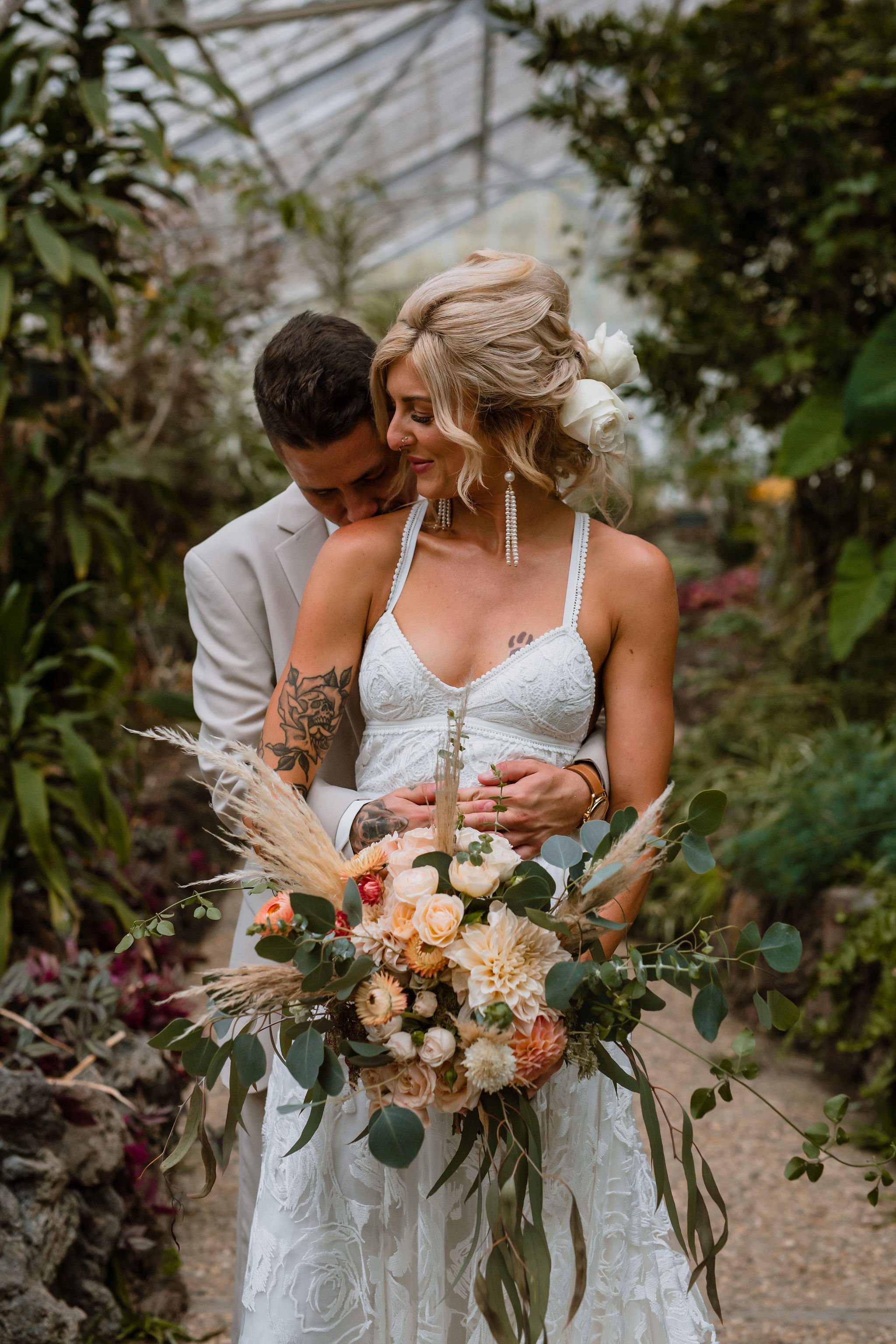 Bride and Groom in the Greenhouse With Bouquet