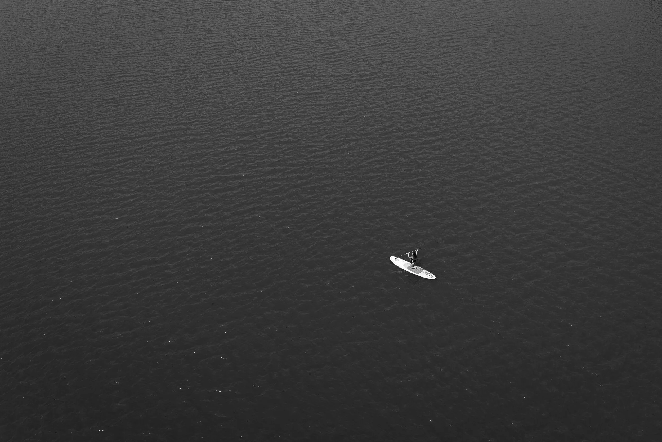 A woman steers a standup paddleboard across the Potomac River in Washington, D.C.