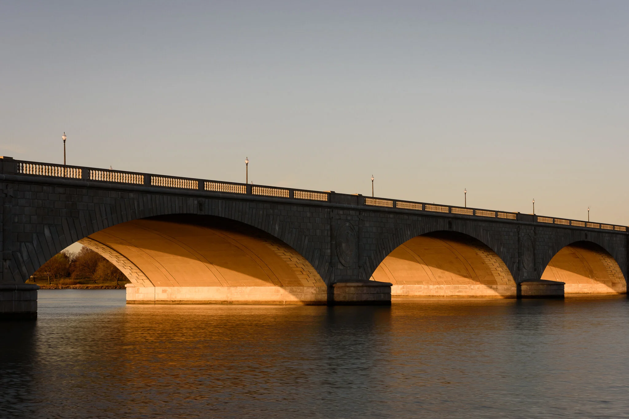 Golden light illuminates the underside of Memorial Bridge in Washington, D.C.
