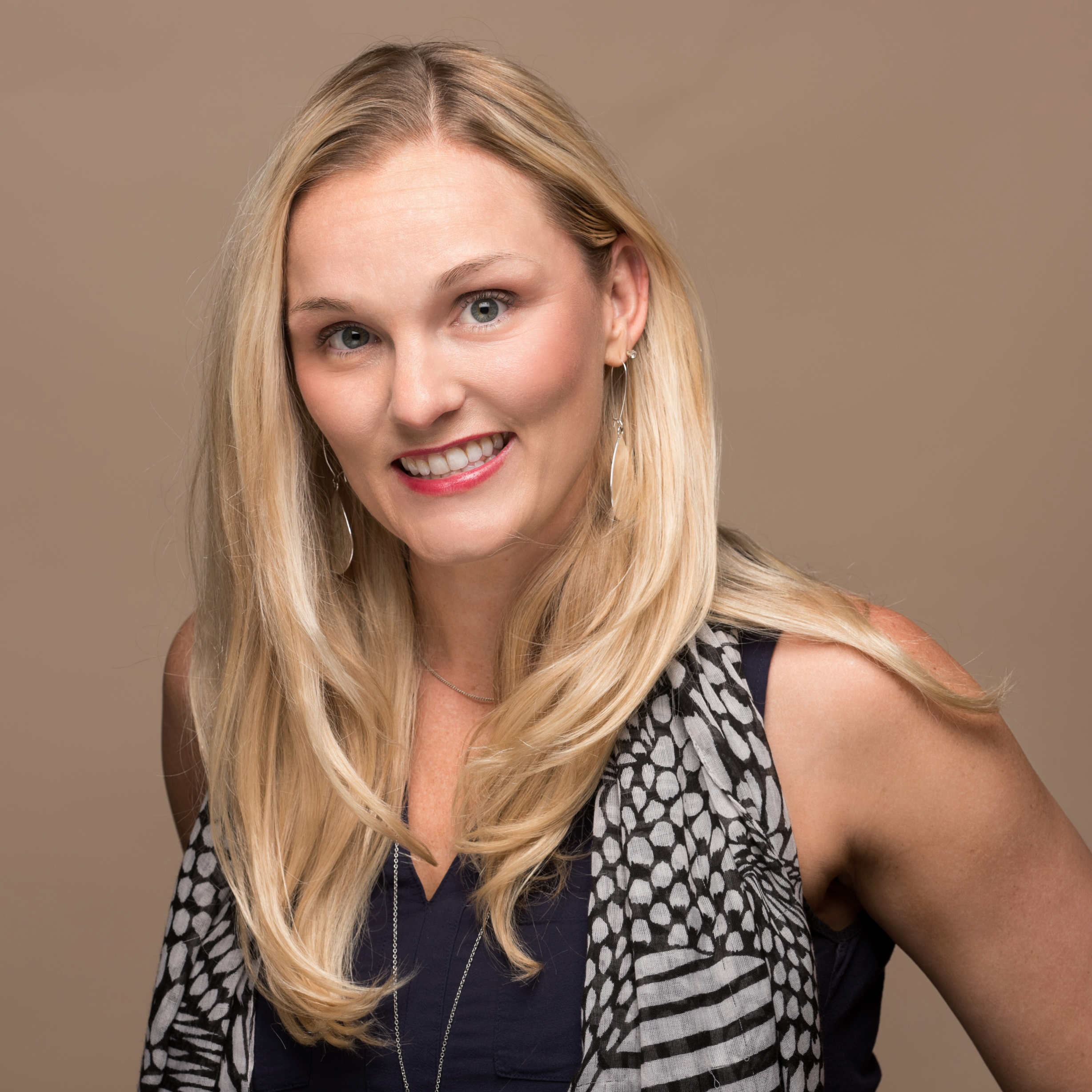 Professional business headshot of a woman in a studio setting.