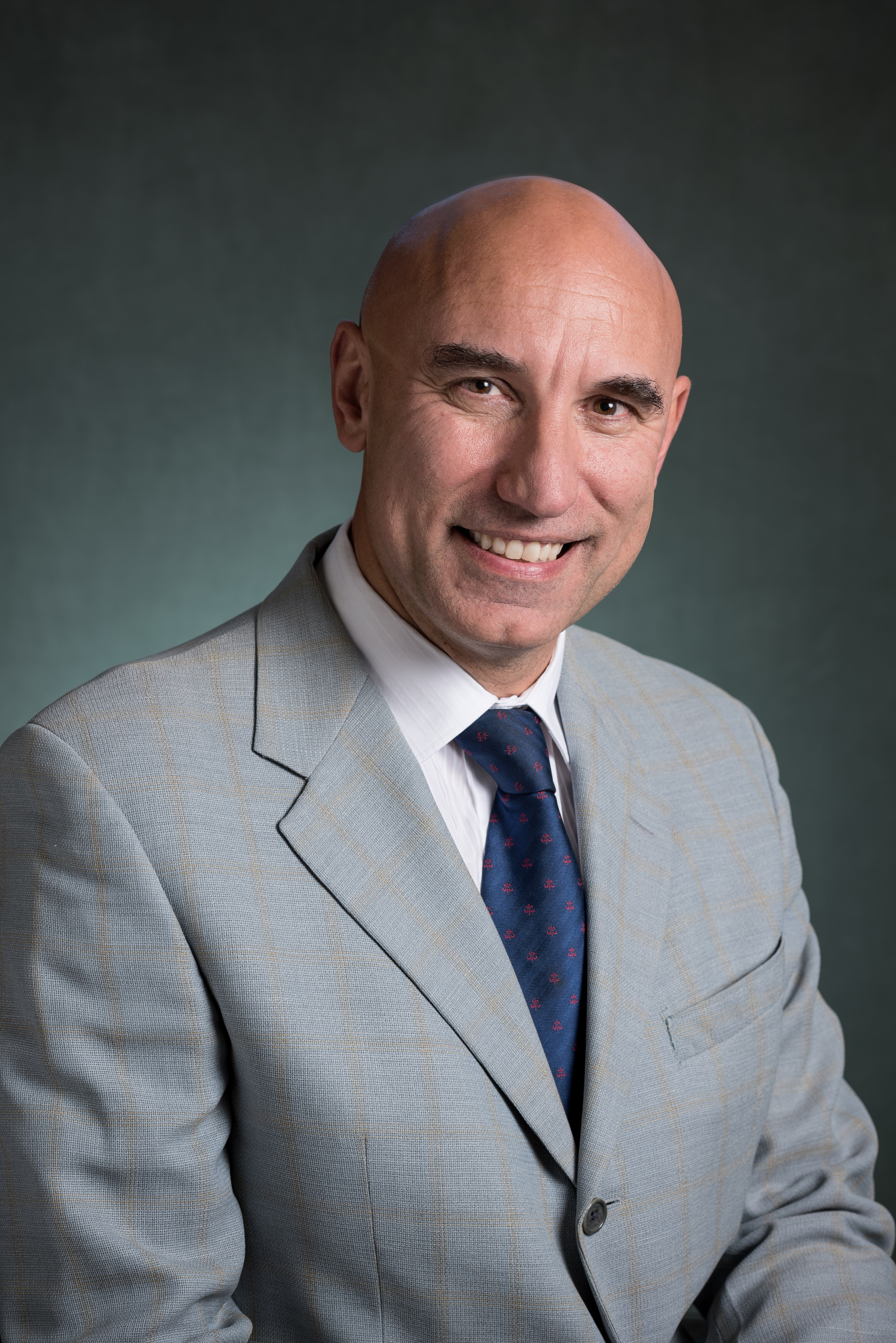 Smiling bald man wearing light gray business suit