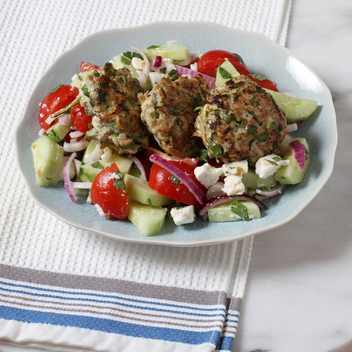 Turkey and zucchini burgers over a tomato and cucumber salad with feta. Yum.  