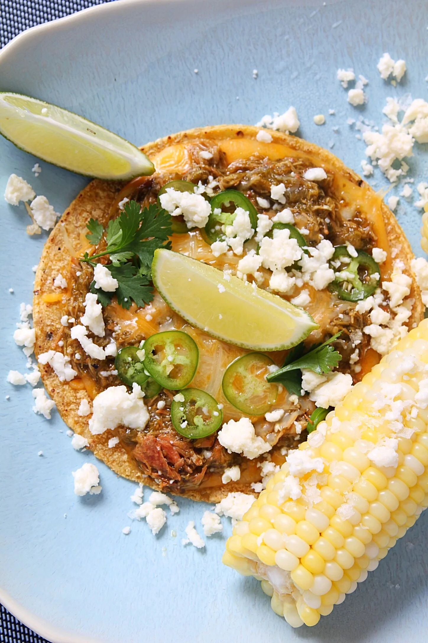 Chicken chili verde taco with Serrano peppers, extra cheese, and corn on the cob