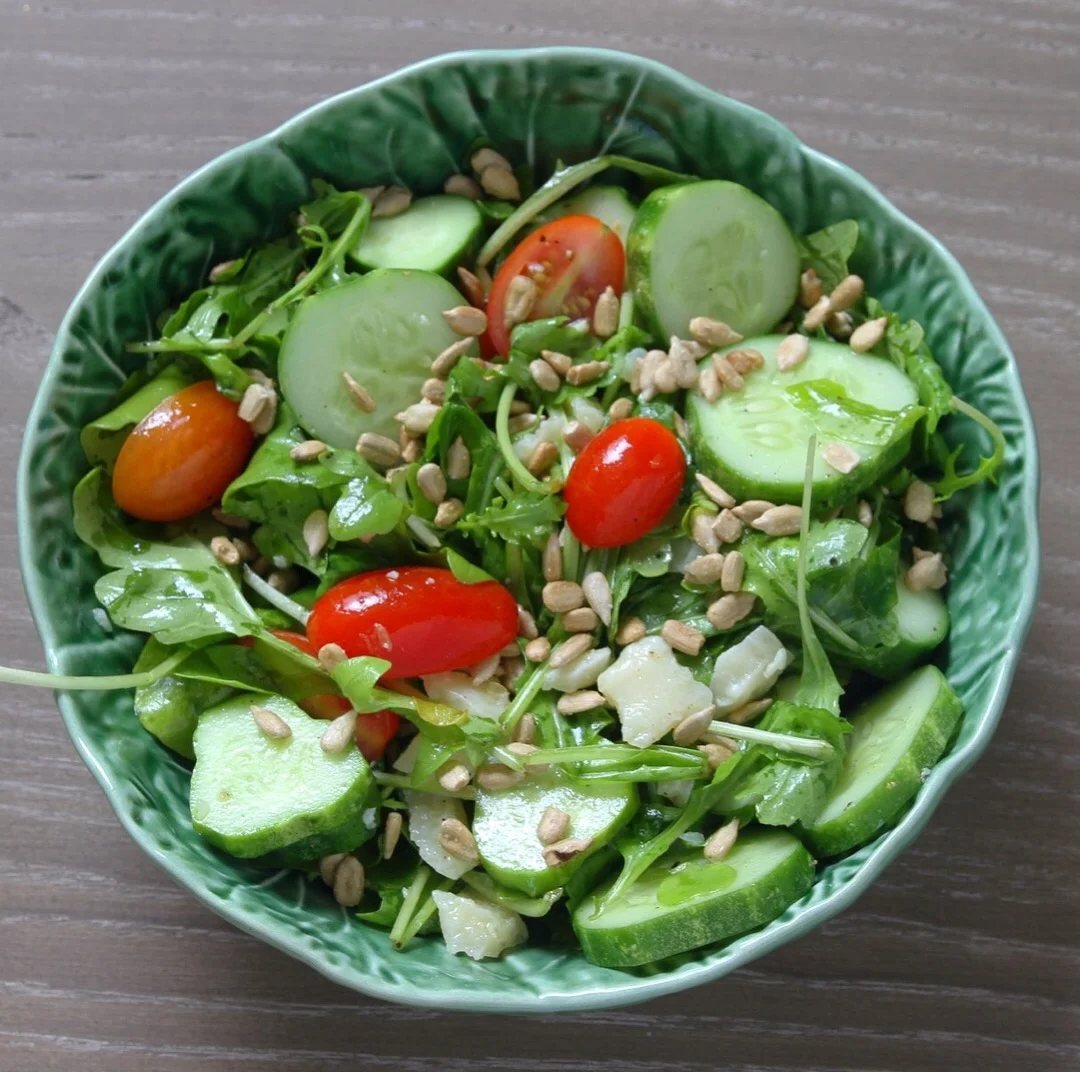 Arugula salad with fresh grape tomatoes, cucumbers, pine nuts, and Parmesan chunks.&nbsp;