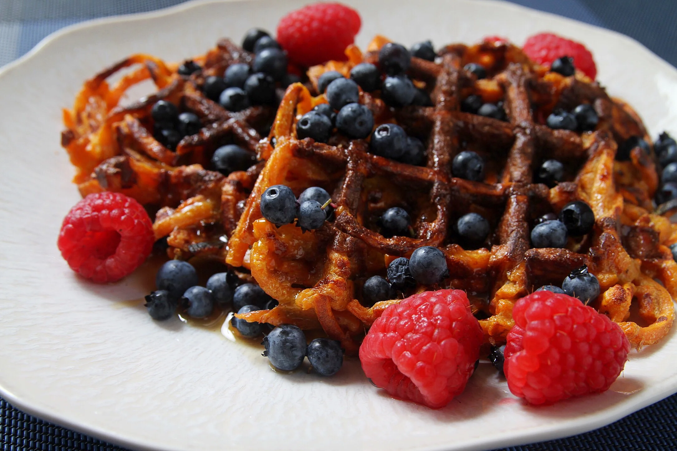 Spiralized sweet potato waffles with pure maple syrup, Maine blueberries, and raspberries. 