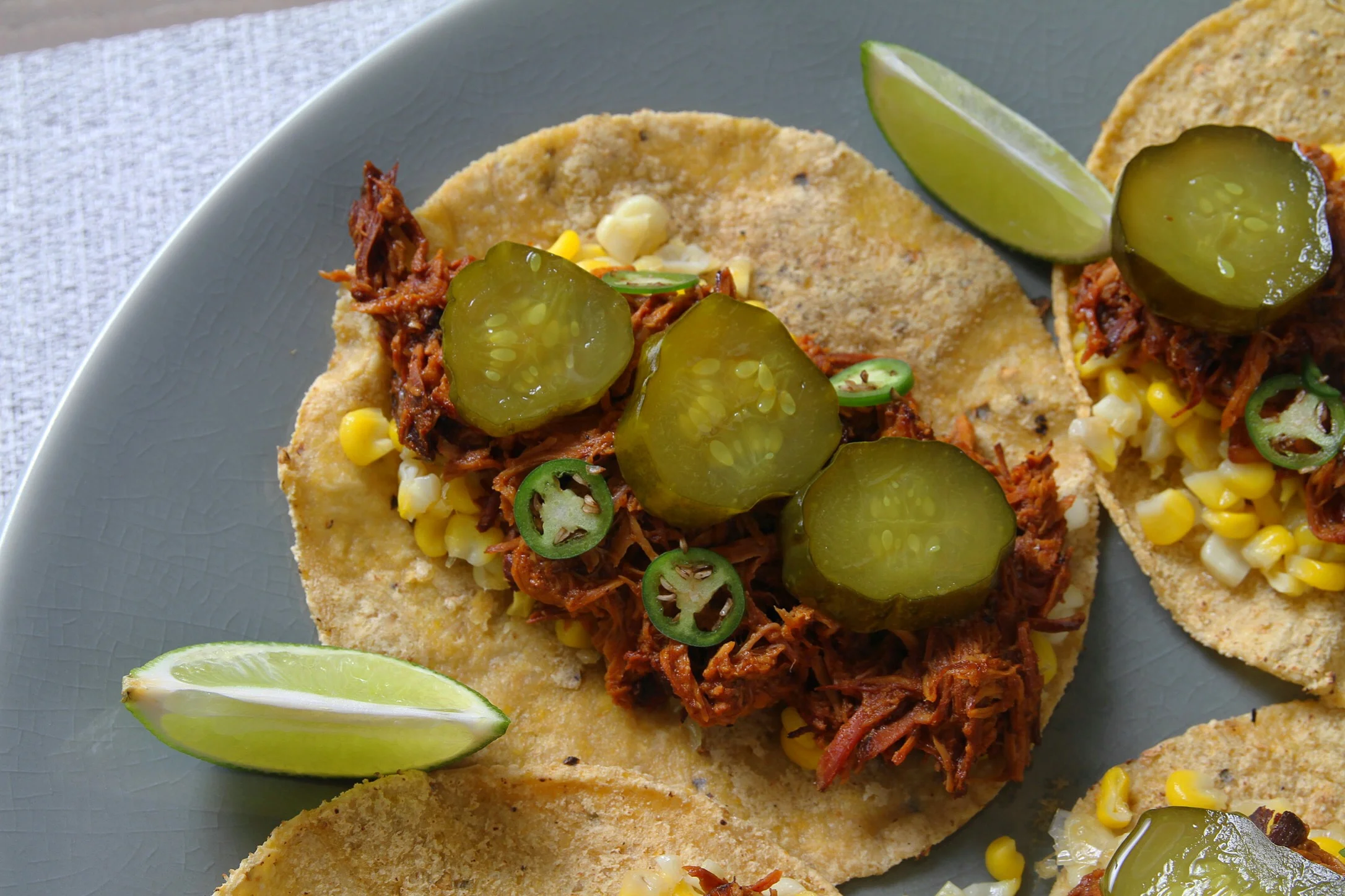 Slow cooker BBQ chicken tacos with homemade pickles, Serrano pepper, and corn. 