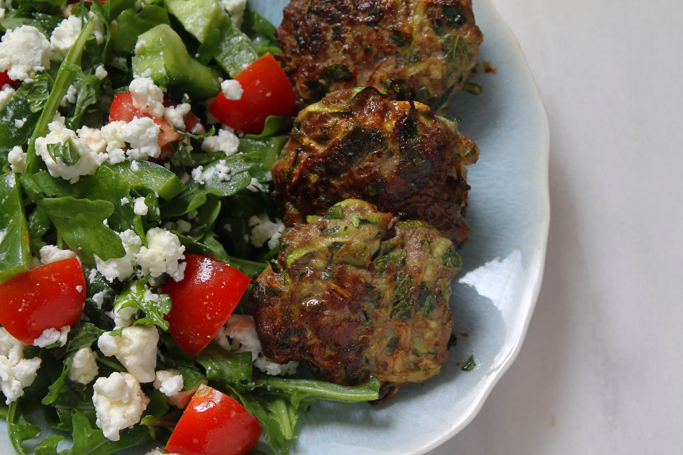 Lamb and zucchini burgers with arugula salad.&nbsp;