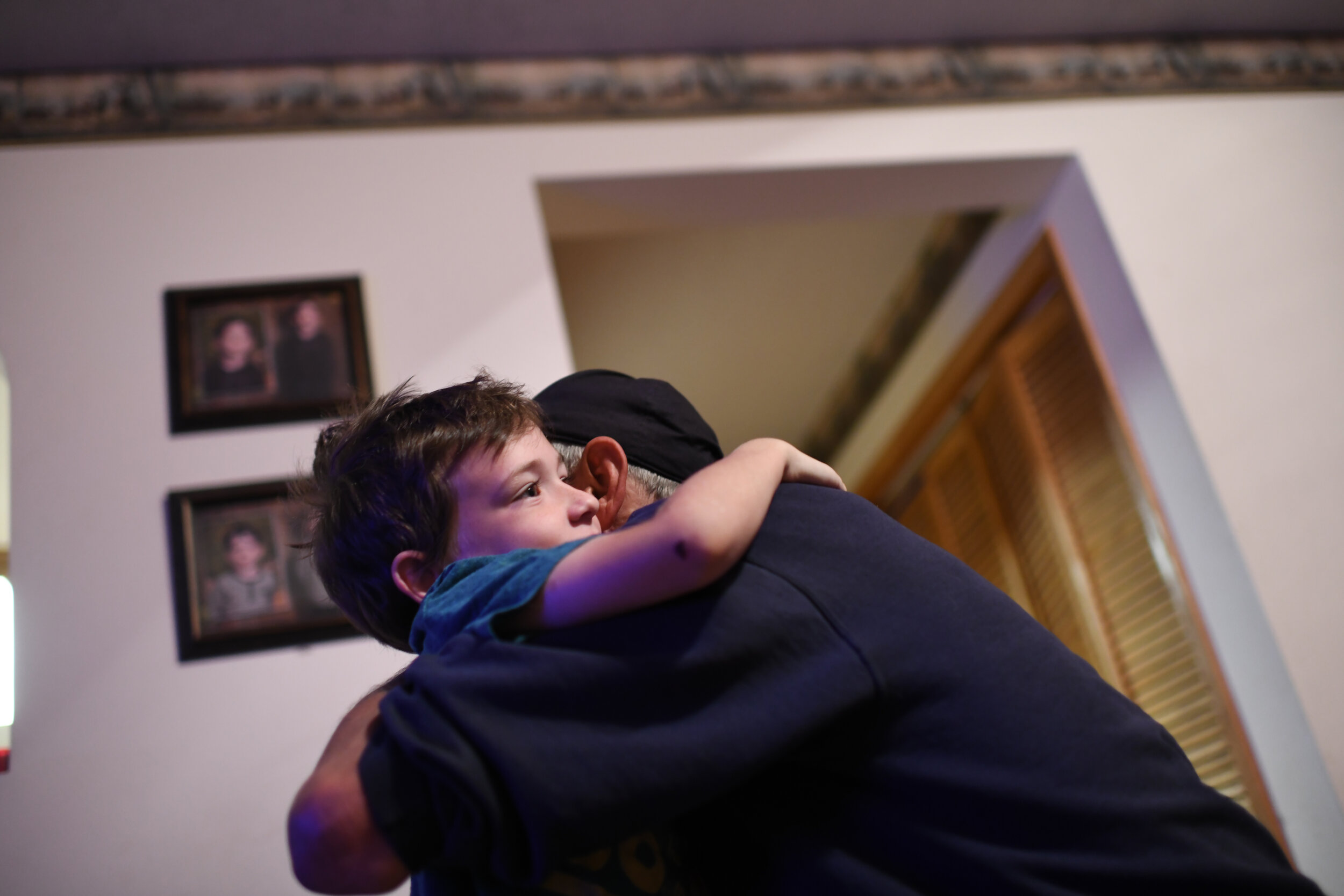  Garrett (left) hugs Eric as he arrives home from work. Eric owns and operates his own mechanic shop in Mountain Grove. 