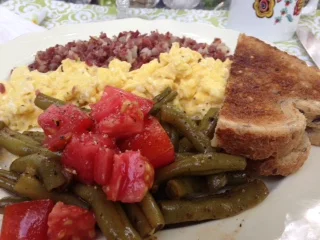 Summer breakfast with local beans and tomato, homemade corned beef hash and wheat bread