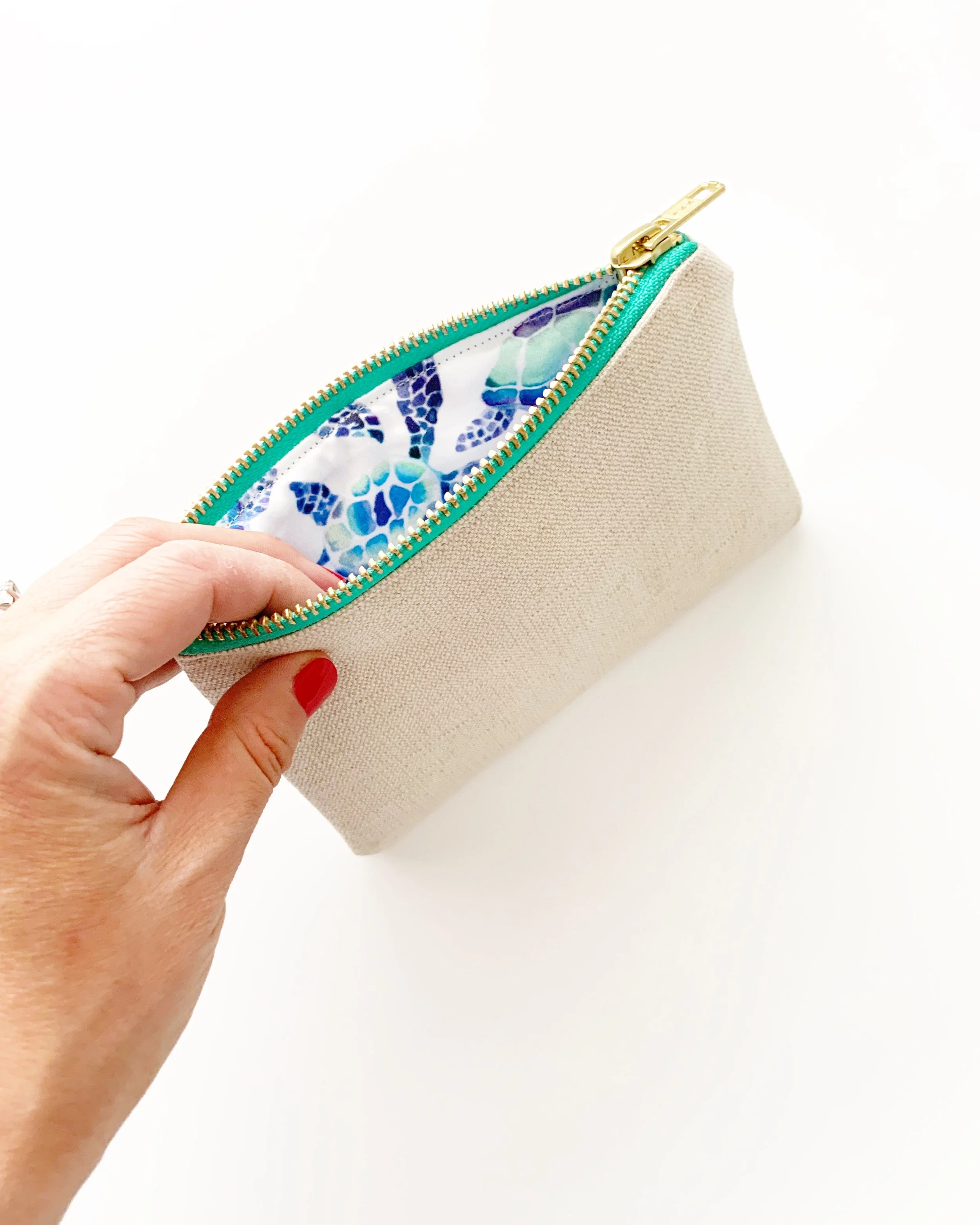 Hand hold open organic cotton hemp purse with white background turtle lining