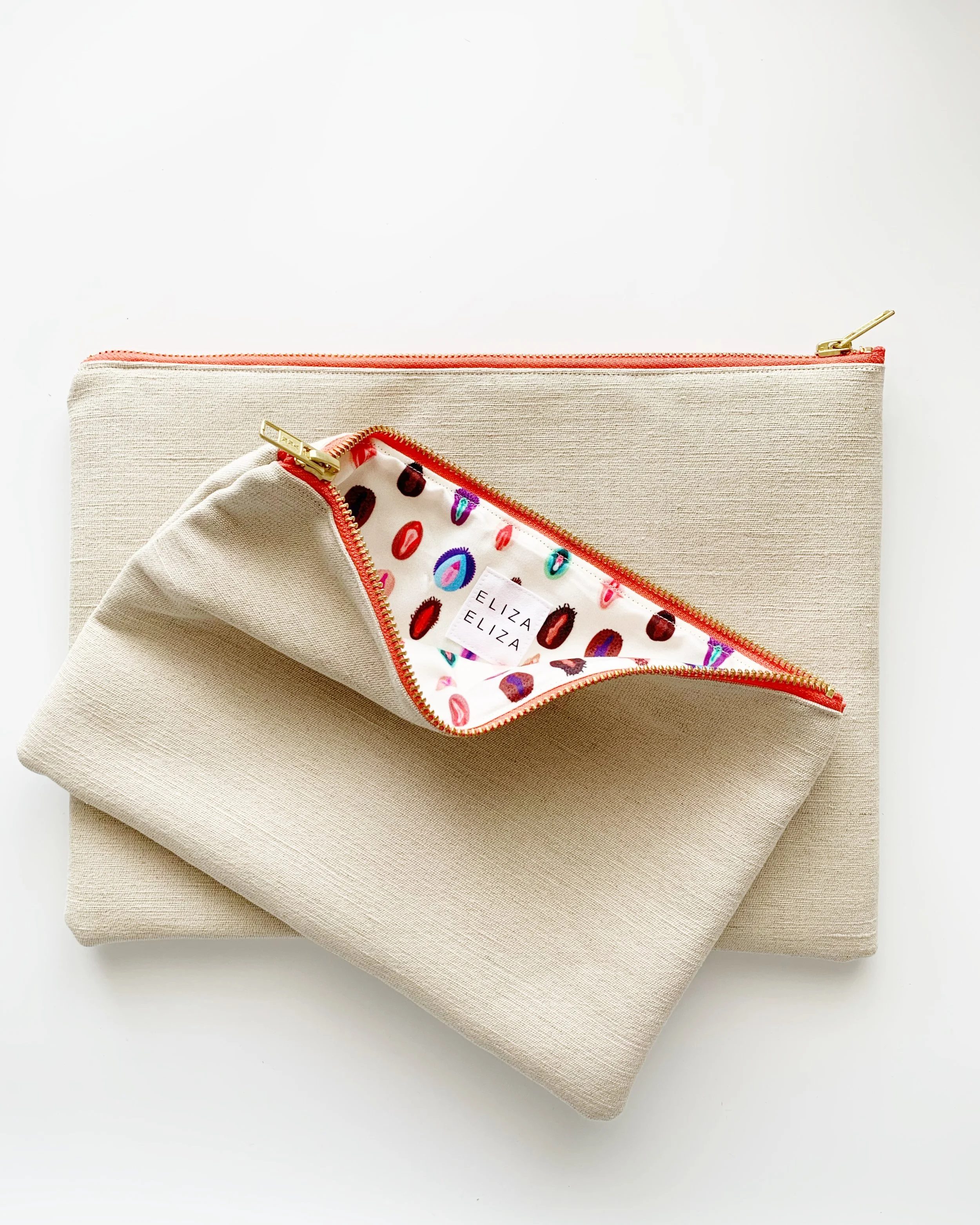 V Collection clutch bag showing lining laying on V Collection large clutch bag