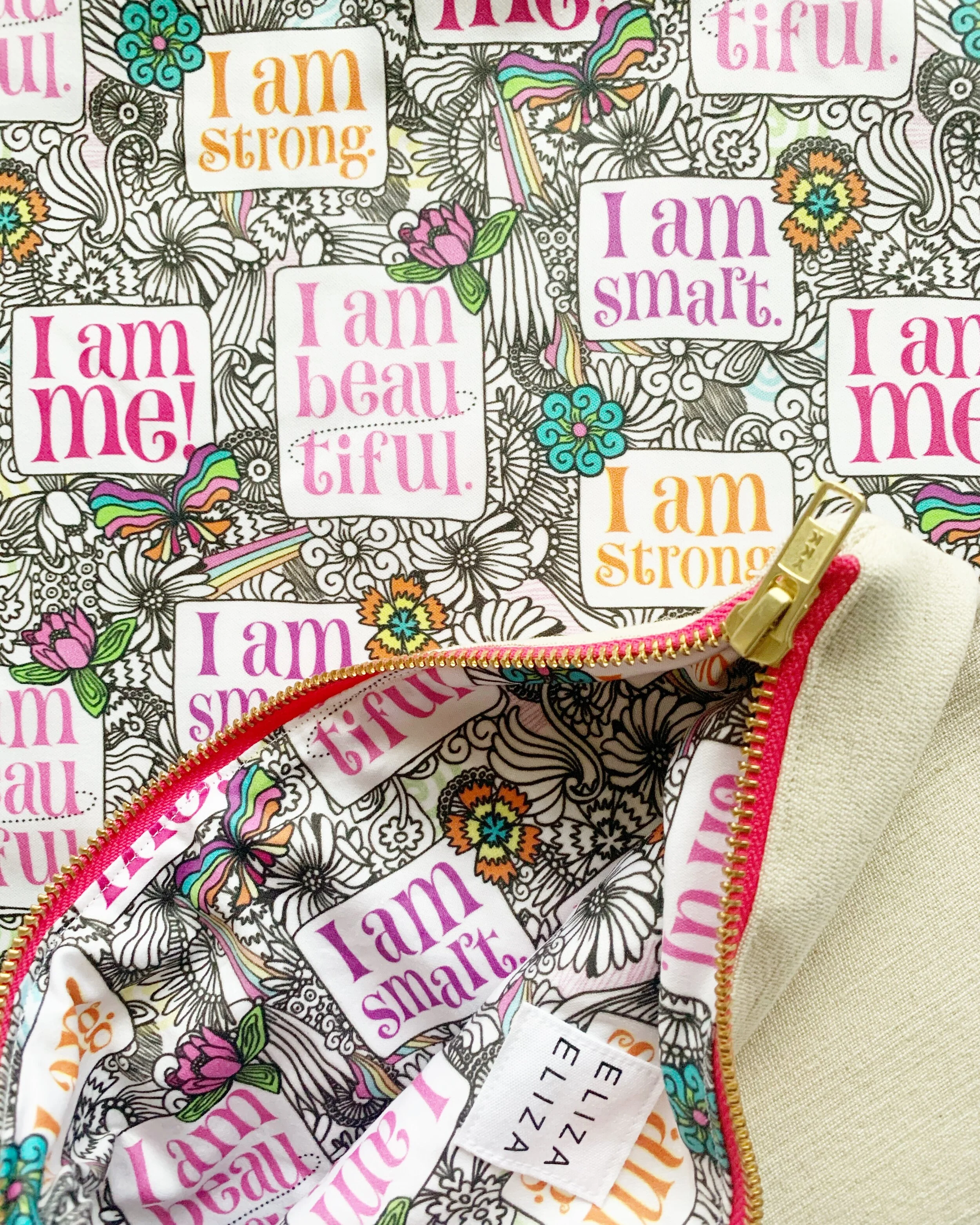 I am Me organic cotton fabric with clutch bag laying on top
