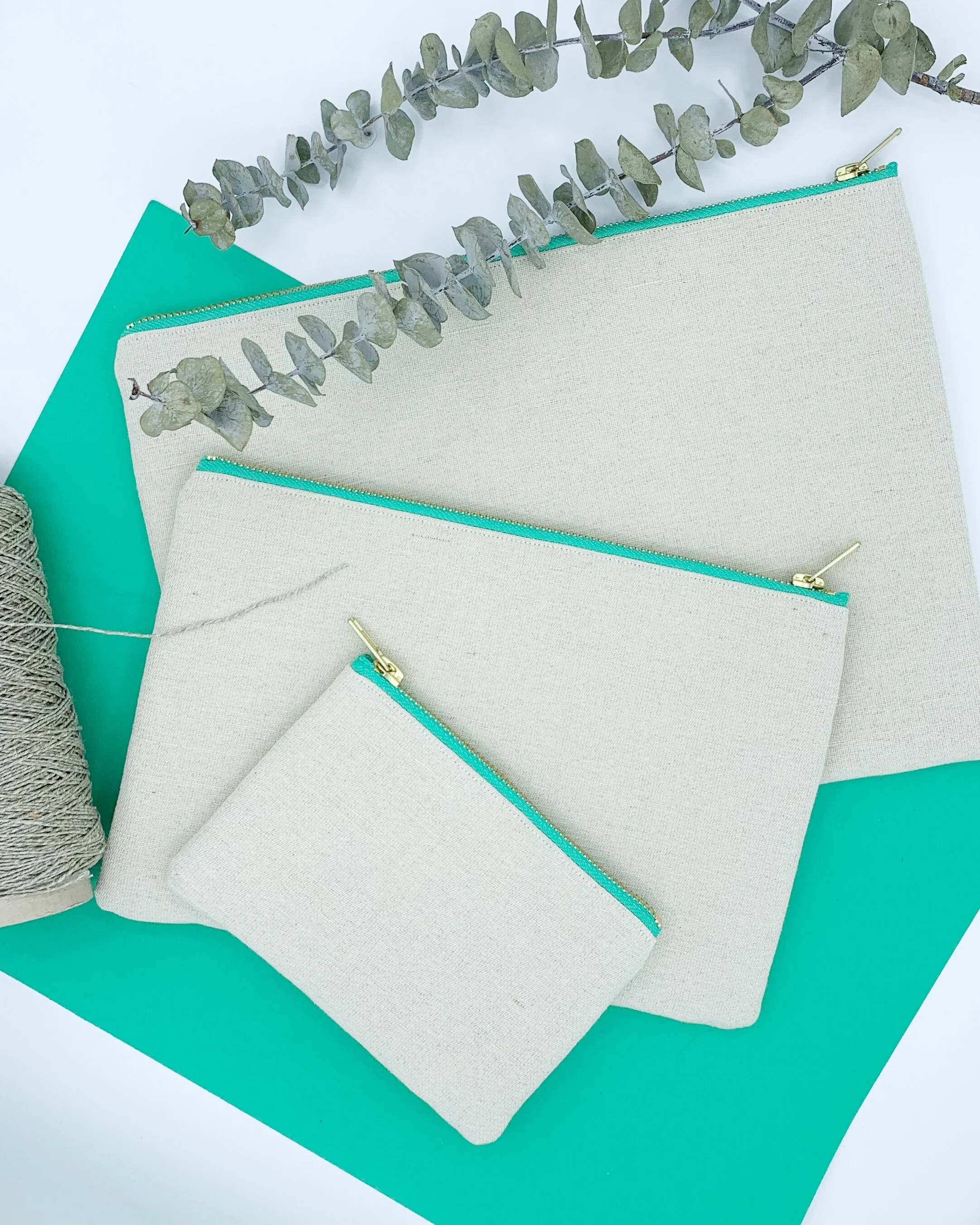 Flat lay organic hemp cotton clutch bags purse on green white background eucalyptus