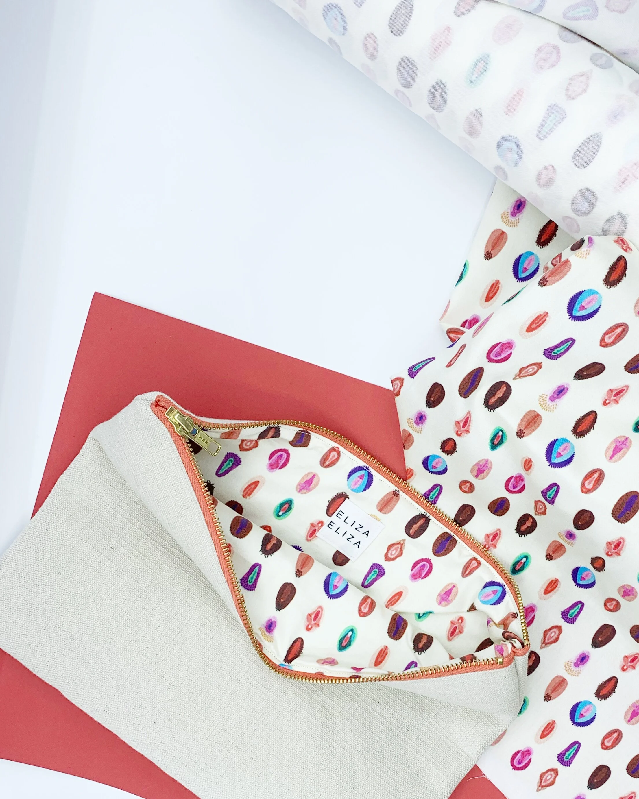 Flat lay of open V Collection Large V Collection with matching fabric on white and red background